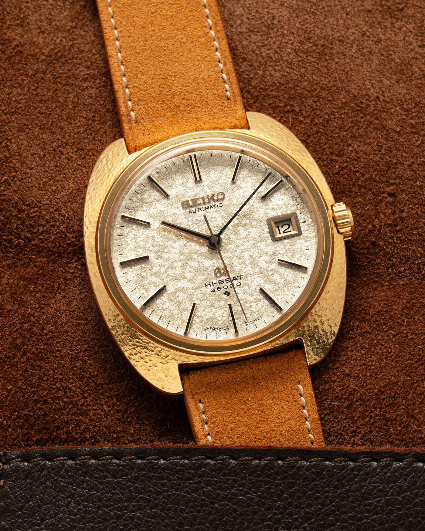 Brand: Grand Seiko
Year: Late 1960’s/1970’s
Model: 61GS
Reference Number: 6145-8030 ‘Kirazuri’
Material: 18-carat Yellow Gold
Movement: Self-Winding Hi Beat Cal. 6145
Case Dimensions: 37mm Diameter 11mm Thickness
Lug Width: 18mm
Strap: Nostime Tan Suede Strap with Generic Stainless Steel Buckle