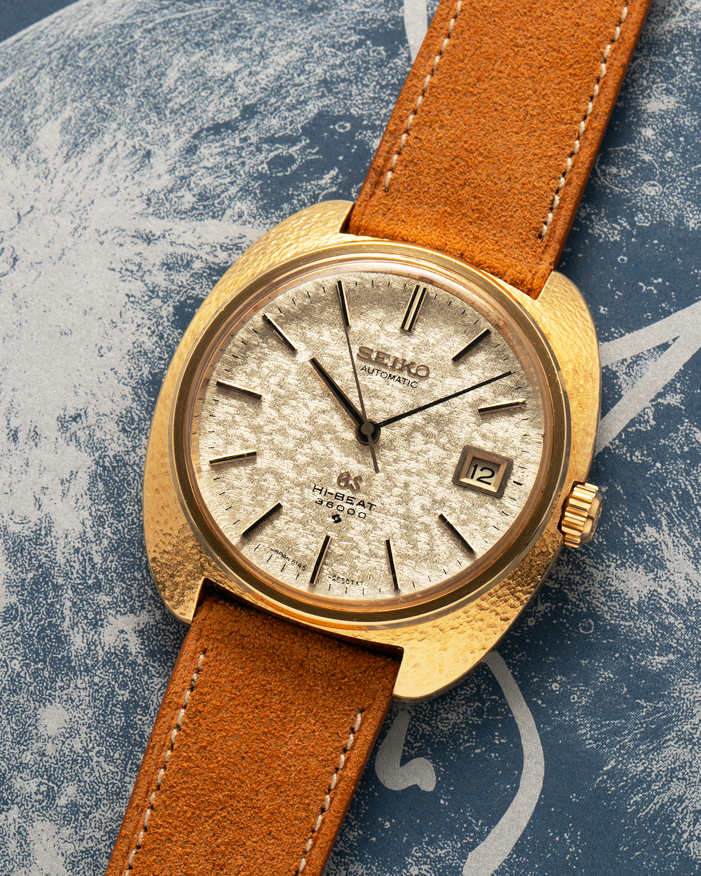 Brand: Grand Seiko
Year: Late 1960’s/1970’s
Model: 61GS
Reference Number: 6145-8030 ‘Kirazuri’
Material: 18-carat Yellow Gold
Movement: Self-Winding Hi Beat Cal. 6145
Case Dimensions: 37mm Diameter 11mm Thickness
Lug Width: 18mm
Strap: Nostime Tan Suede Strap with Generic Stainless Steel Buckle