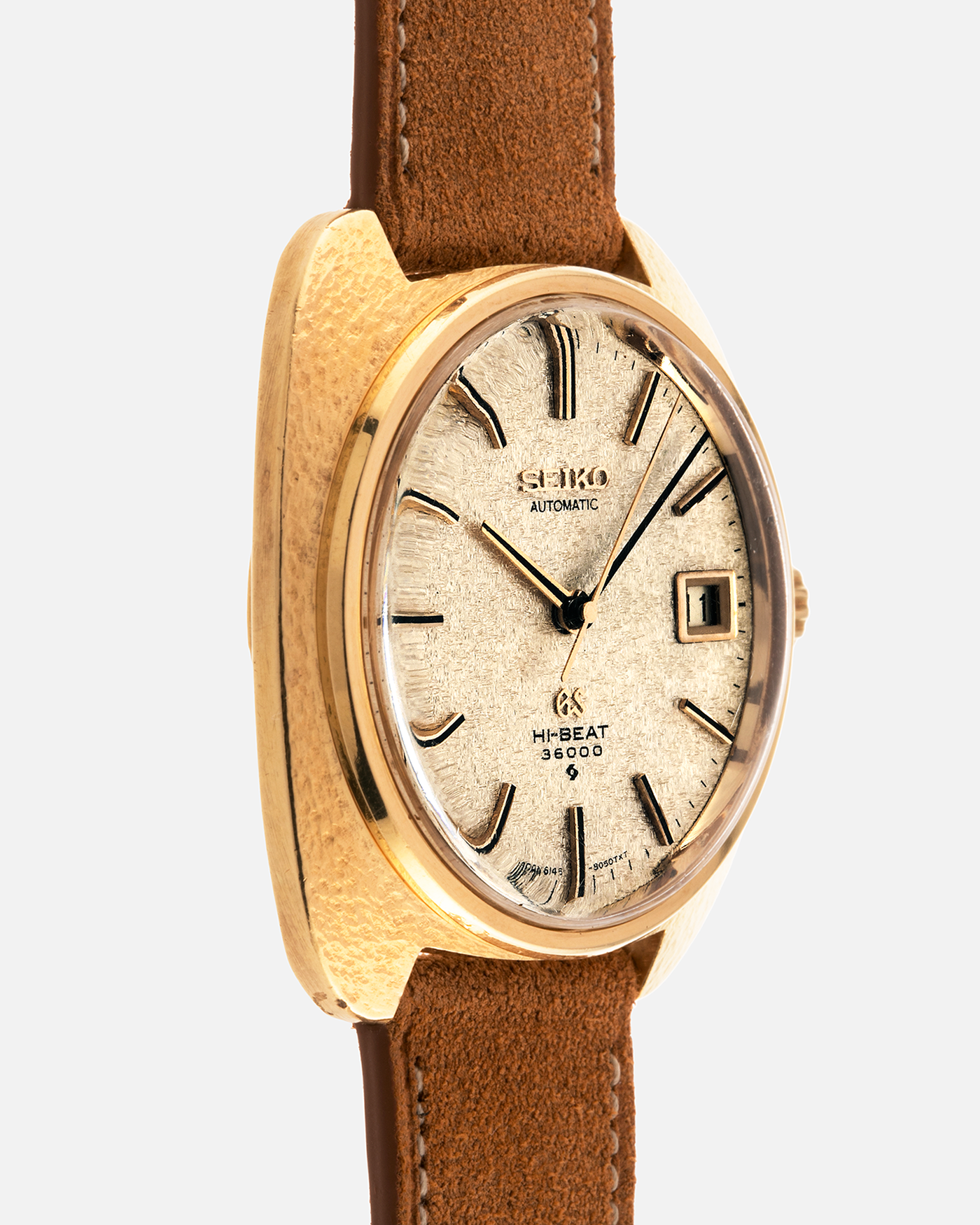 Brand: Grand Seiko
Year: Late 1960’s/1970’s
Model: 61GS
Reference Number: 6145-8030 ‘Kirazuri’
Material: 18-carat Yellow Gold
Movement: Self-Winding Hi Beat Cal. 6145
Case Dimensions: 37mm Diameter 11mm Thickness
Lug Width: 18mm
Strap: Nostime Tan Suede Strap with Generic Stainless Steel Buckle
