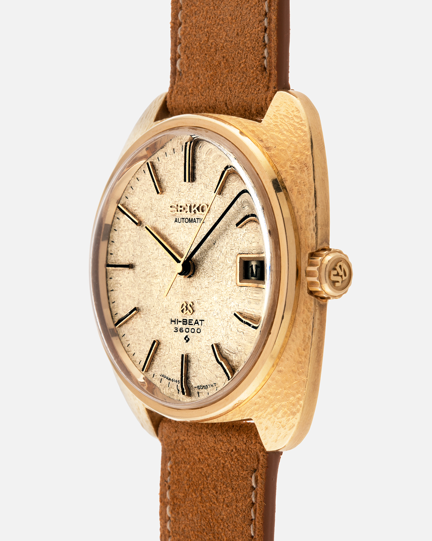 Brand: Grand Seiko
Year: Late 1960’s/1970’s
Model: 61GS
Reference Number: 6145-8030 ‘Kirazuri’
Material: 18-carat Yellow Gold
Movement: Self-Winding Hi Beat Cal. 6145
Case Dimensions: 37mm Diameter 11mm Thickness
Lug Width: 18mm
Strap: Nostime Tan Suede Strap with Generic Stainless Steel Buckle