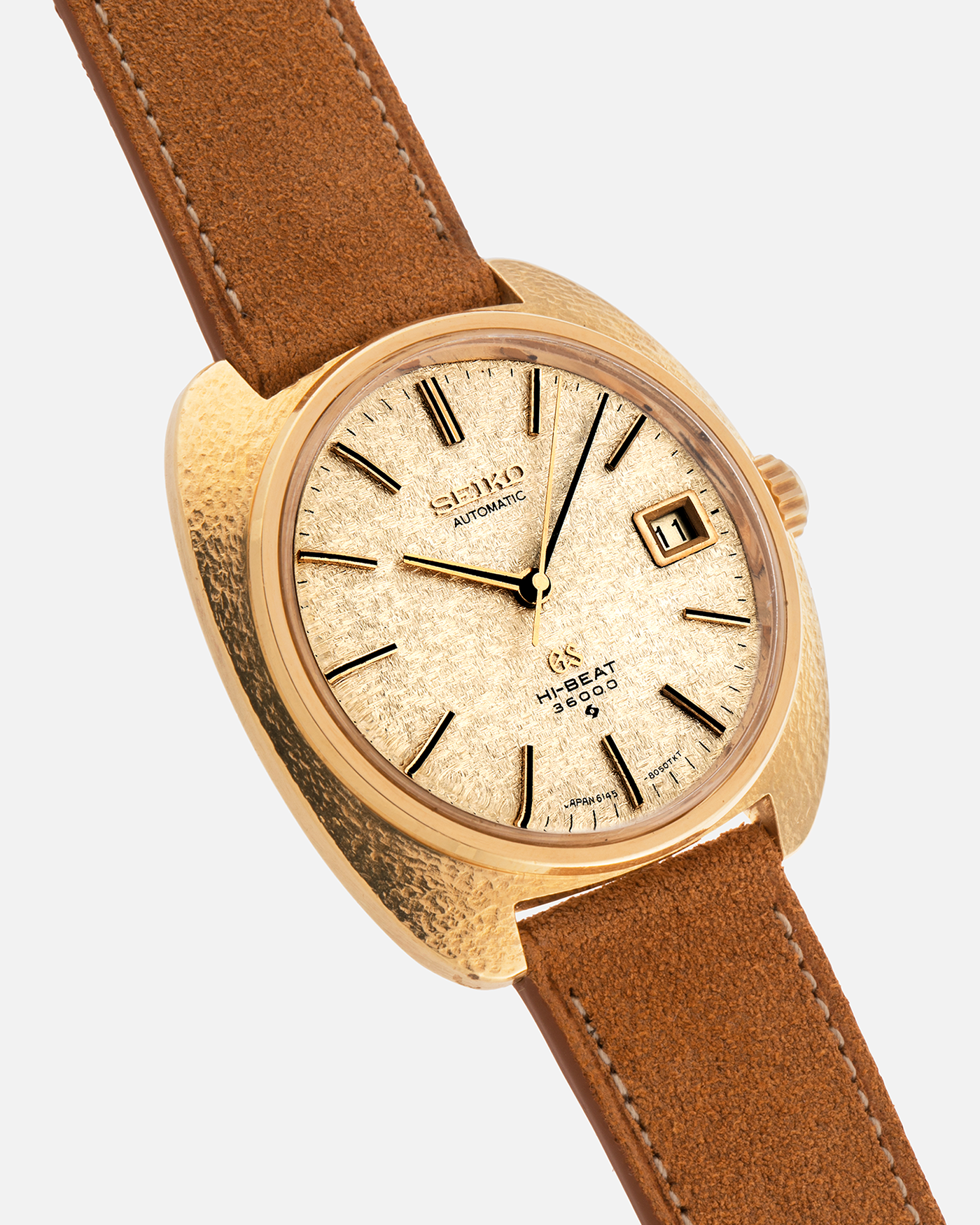Brand: Grand Seiko
Year: Late 1960’s/1970’s
Model: 61GS
Reference Number: 6145-8030 ‘Kirazuri’
Material: 18-carat Yellow Gold
Movement: Self-Winding Hi Beat Cal. 6145
Case Dimensions: 37mm Diameter 11mm Thickness
Lug Width: 18mm
Strap: Nostime Tan Suede Strap with Generic Stainless Steel Buckle