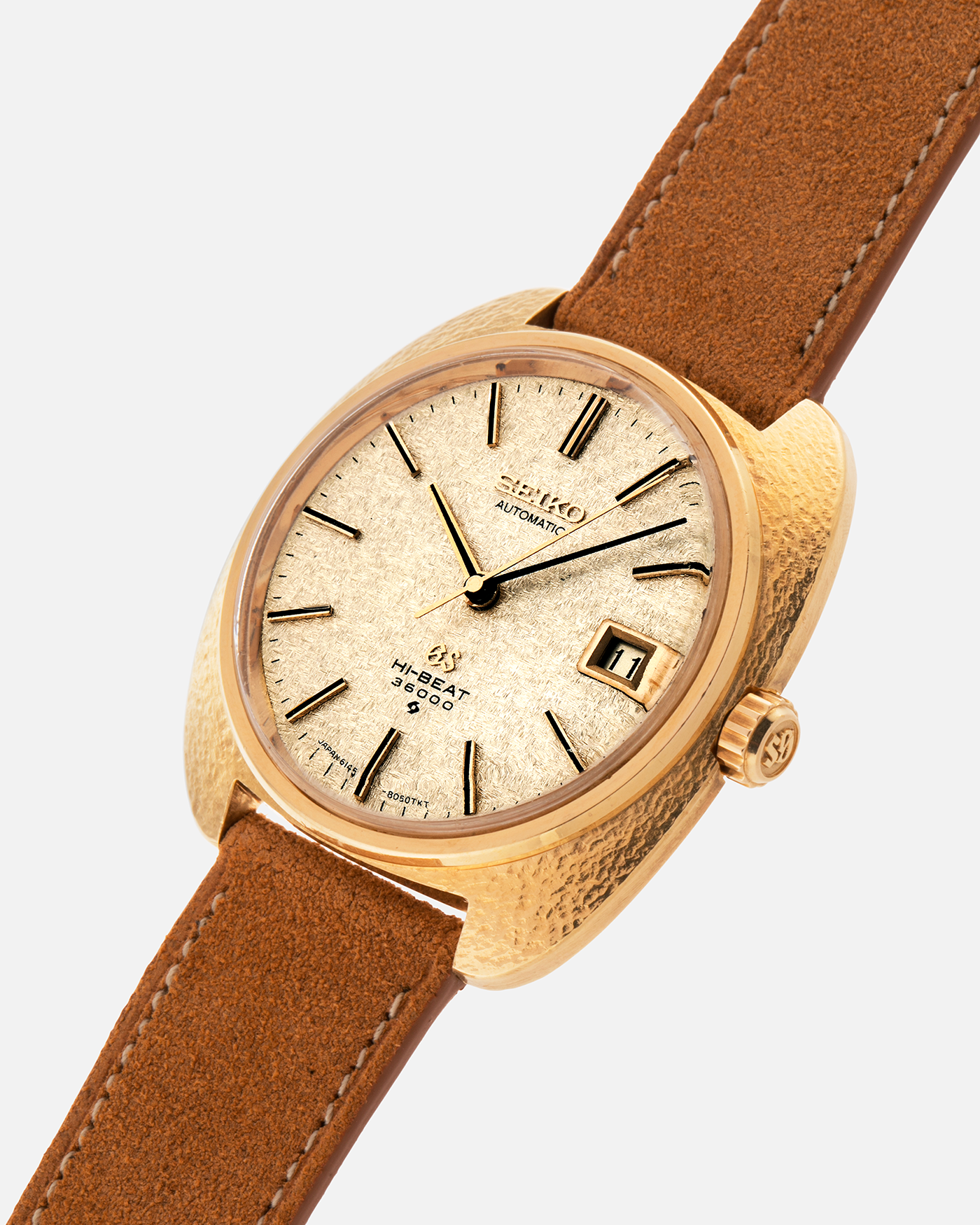Brand: Grand Seiko
Year: Late 1960’s/1970’s
Model: 61GS
Reference Number: 6145-8030 ‘Kirazuri’
Material: 18-carat Yellow Gold
Movement: Self-Winding Hi Beat Cal. 6145
Case Dimensions: 37mm Diameter 11mm Thickness
Lug Width: 18mm
Strap: Nostime Tan Suede Strap with Generic Stainless Steel Buckle