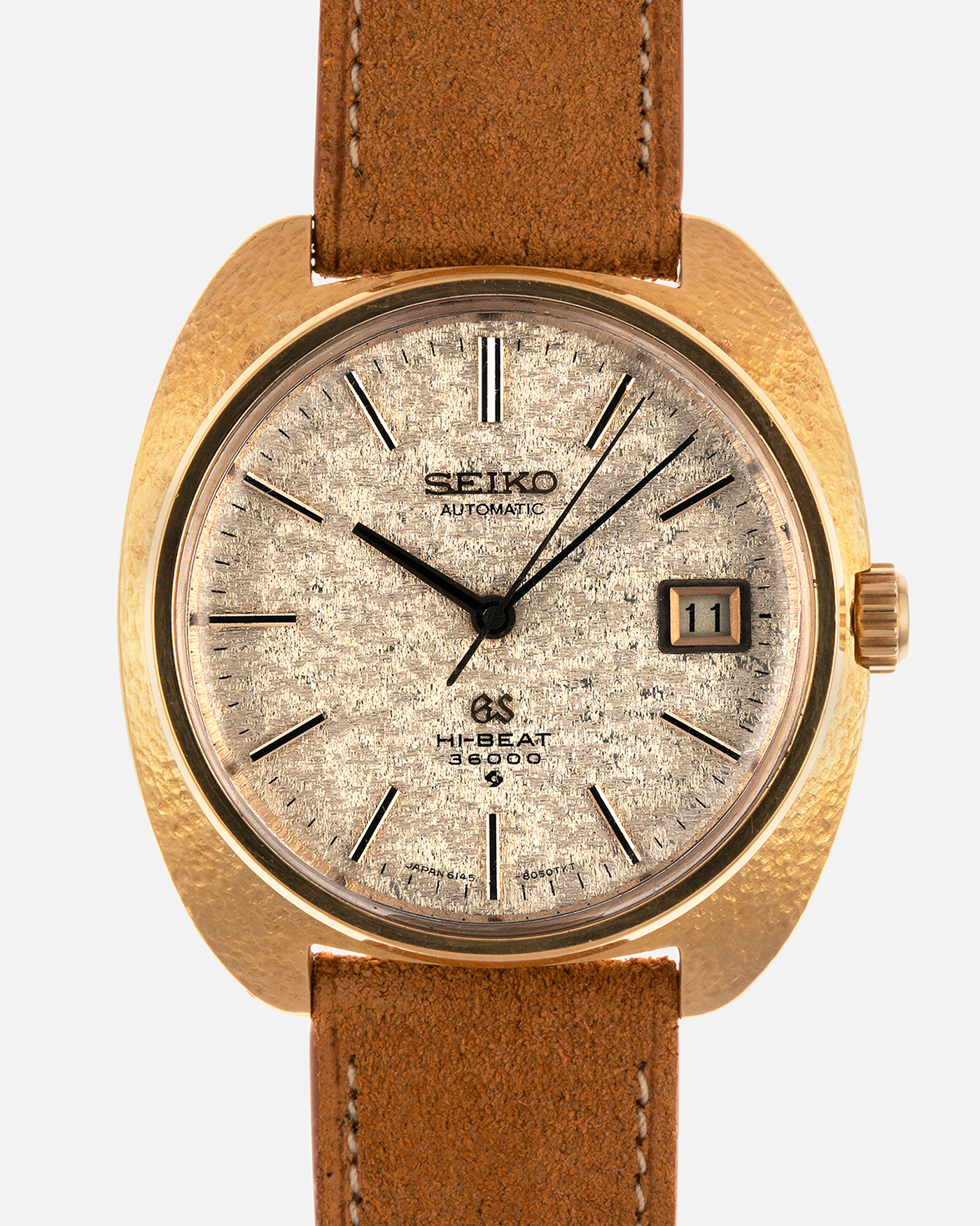 Brand: Grand Seiko
Year: Late 1960’s/1970’s
Model: 61GS
Reference Number: 6145-8030 ‘Kirazuri’
Material: 18-carat Yellow Gold
Movement: Self-Winding Hi Beat Cal. 6145
Case Dimensions: 37mm Diameter 11mm Thickness
Lug Width: 18mm
Strap: Nostime Tan Suede Strap with Generic Stainless Steel Buckle
