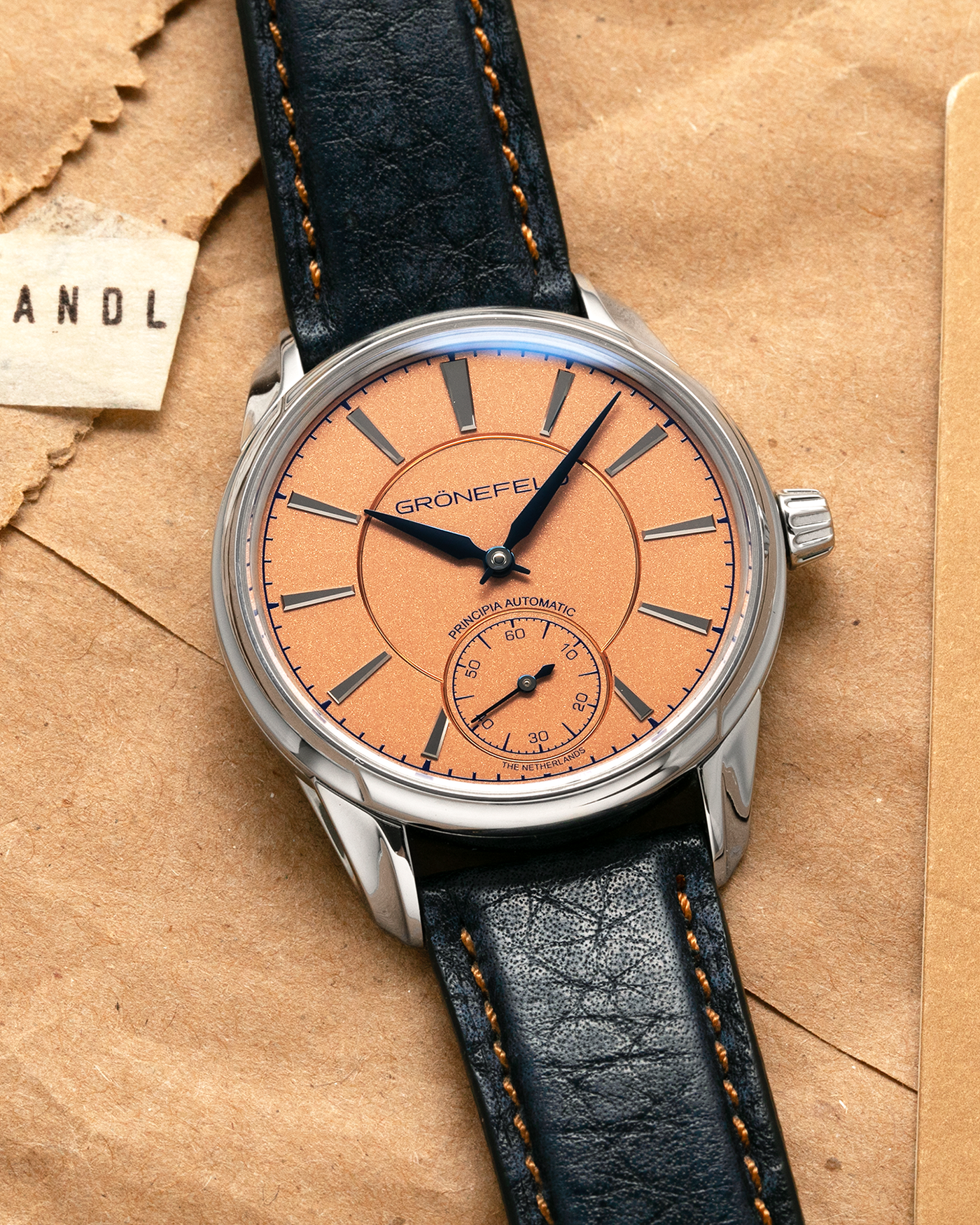Brand: Grönefeld
Year: 2022
Model: 1941 Principia ‘Salmon’
Material: Stainless Steel
Movement: Grönefeld Cal. G-06, Self-Winding
Case Dimensions: 39.5mm x 10.5mm (Lug-to-Lug 47mm)
Lug Width: 20mm
Strap: Grönefeld Blue Buffalo Leather Strap with Orange Stitching, with Grönefeld Stainless Steel Tang Buckle