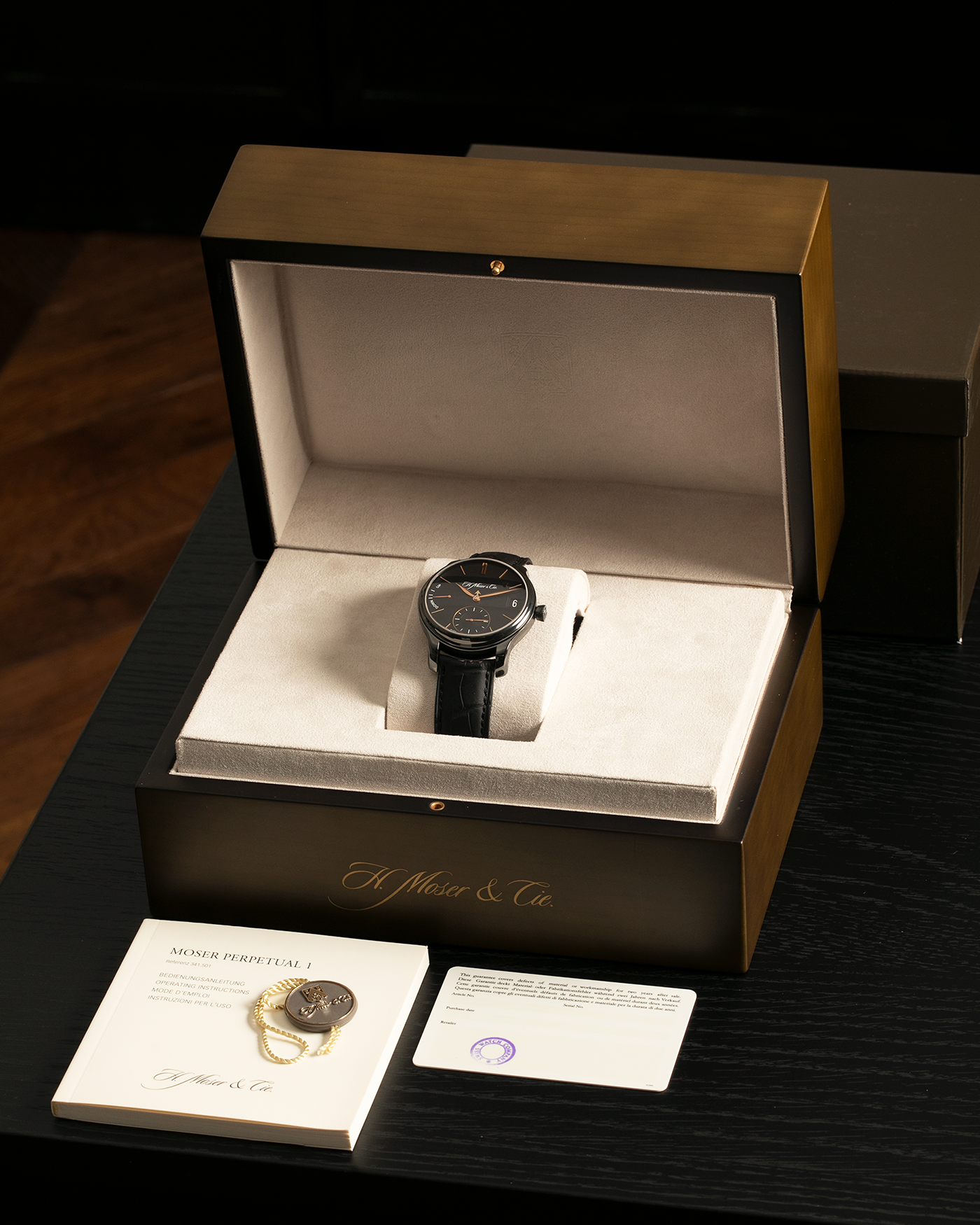 Brand: H. Moser & Cie
Year: Approximately 2016 (Guarantee Card Undated)
Model: Endeavour Perpetual Calendar Black Edition
Reference Number: 341.050-020
Material: DLC-Coated Grade 5 Titanium
Movement: H. Moser Cal. HMC 341, Manual-Winding
Case Dimensions: 40.8mm x 11.1 (Lug-to-Lug 47mm)
Lug Width: 20mm
Strap: H. Moser Black Calf Leather Strap with Signed DLC-Coated Titanium Tang Buckle