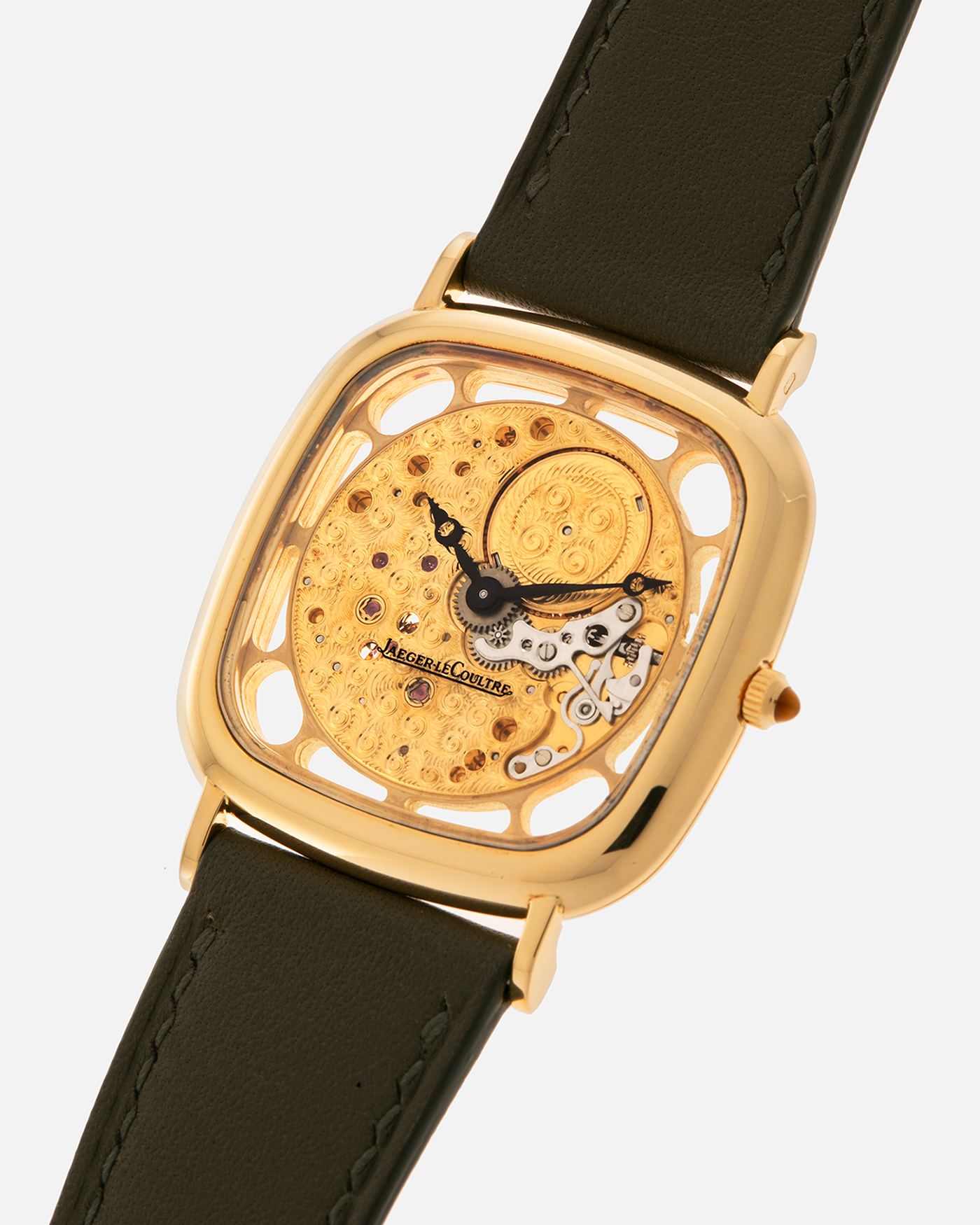 Brand: Jaeger-LeCoultre
Reference: 141.007.1 Skeleton
Year: 1981
Material: 18-carat Yellow Gold Case, 14-Carat Yellow Gold Movement, Tiger Eye Cabochon
Movement: Jaeger-LeCoultre Cal. 839, Skeletonized and Manual-Winding
Case Dimensions: 33mm x 4.9mm (Lug-to-Lug 38mm)
Lug Width: 18mm
Strap: Custom Olive Green Calf Leather Strap with Mustard-Yellow Underlining