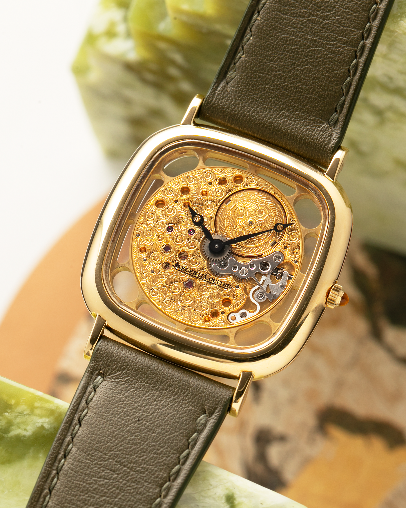Brand: Jaeger-LeCoultre
Reference: 141.007.1 Skeleton
Year: 1981
Material: 18-carat Yellow Gold Case, 14-Carat Yellow Gold Movement, Tiger Eye Cabochon
Movement: Jaeger-LeCoultre Cal. 839, Skeletonized and Manual-Winding
Case Dimensions: 33mm x 4.9mm (Lug-to-Lug 38mm)
Lug Width: 18mm
Strap: Custom Olive Green Calf Leather Strap with Mustard-Yellow Underlining