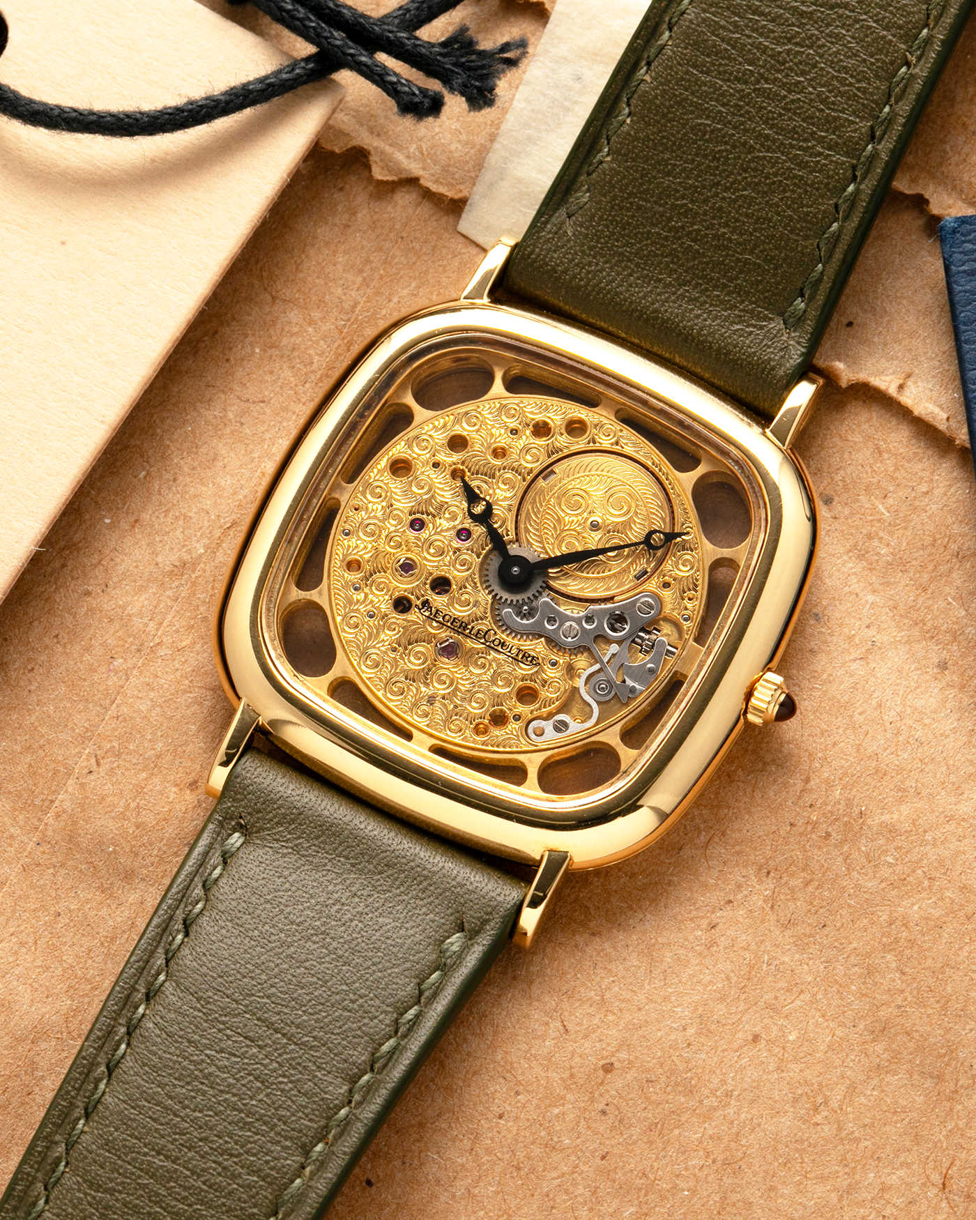 Brand: Jaeger-LeCoultre
Reference: 141.007.1 Skeleton
Year: 1981
Material: 18-carat Yellow Gold Case, 14-Carat Yellow Gold Movement, Tiger Eye Cabochon
Movement: Jaeger-LeCoultre Cal. 839, Skeletonized and Manual-Winding
Case Dimensions: 33mm x 4.9mm (Lug-to-Lug 38mm)
Lug Width: 18mm
Strap: Custom Olive Green Calf Leather Strap with Mustard-Yellow Underlining