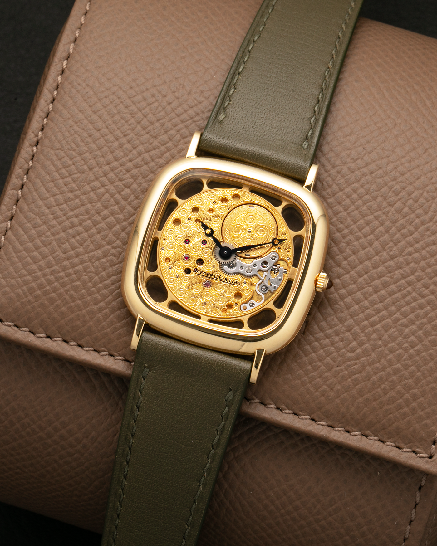 Brand: Jaeger-LeCoultre
Reference: 141.007.1 Skeleton
Year: 1981
Material: 18-carat Yellow Gold Case, 14-Carat Yellow Gold Movement, Tiger Eye Cabochon
Movement: Jaeger-LeCoultre Cal. 839, Skeletonized and Manual-Winding
Case Dimensions: 33mm x 4.9mm (Lug-to-Lug 38mm)
Lug Width: 18mm
Strap: Custom Olive Green Calf Leather Strap with Mustard-Yellow Underlining