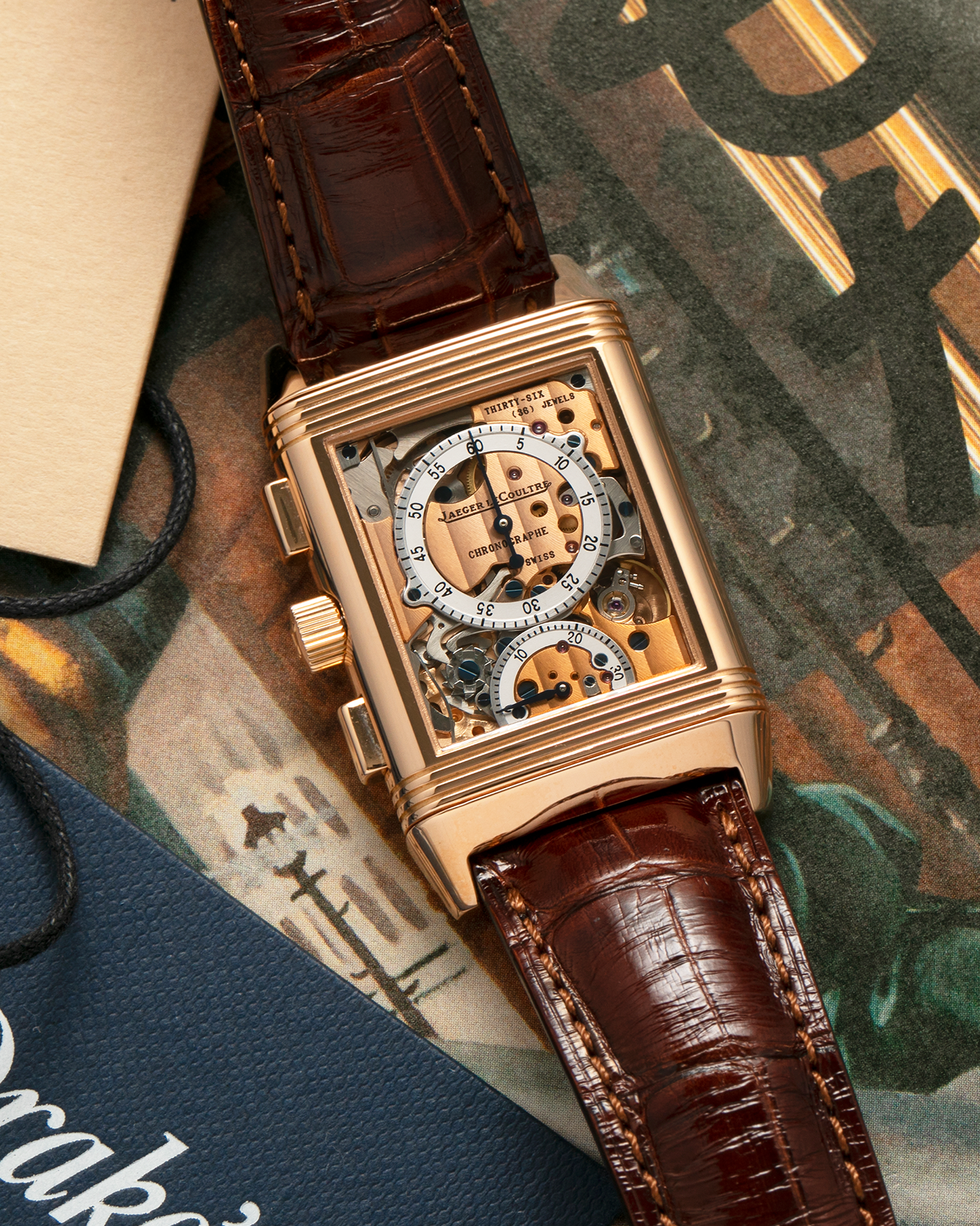 Brand: Jaeger LeCoultre
Year: 1996
Model: Reverso Chronographe Retrograde, Limited to 500 pieces
Reference: 270.2.69
Material: 18-carat Rose Gold
Movement: Jaeger LeCoultre Cal. 829, Manual-Winding
Case Dimensions: 42mm (including lugs) x 26mm x 9.5mm
Lug Width: 19mm
Strap: Jean Rosseau Brown Alligator Leather Strap with Signed 18-carat Rose Gold Deployant Clasp
