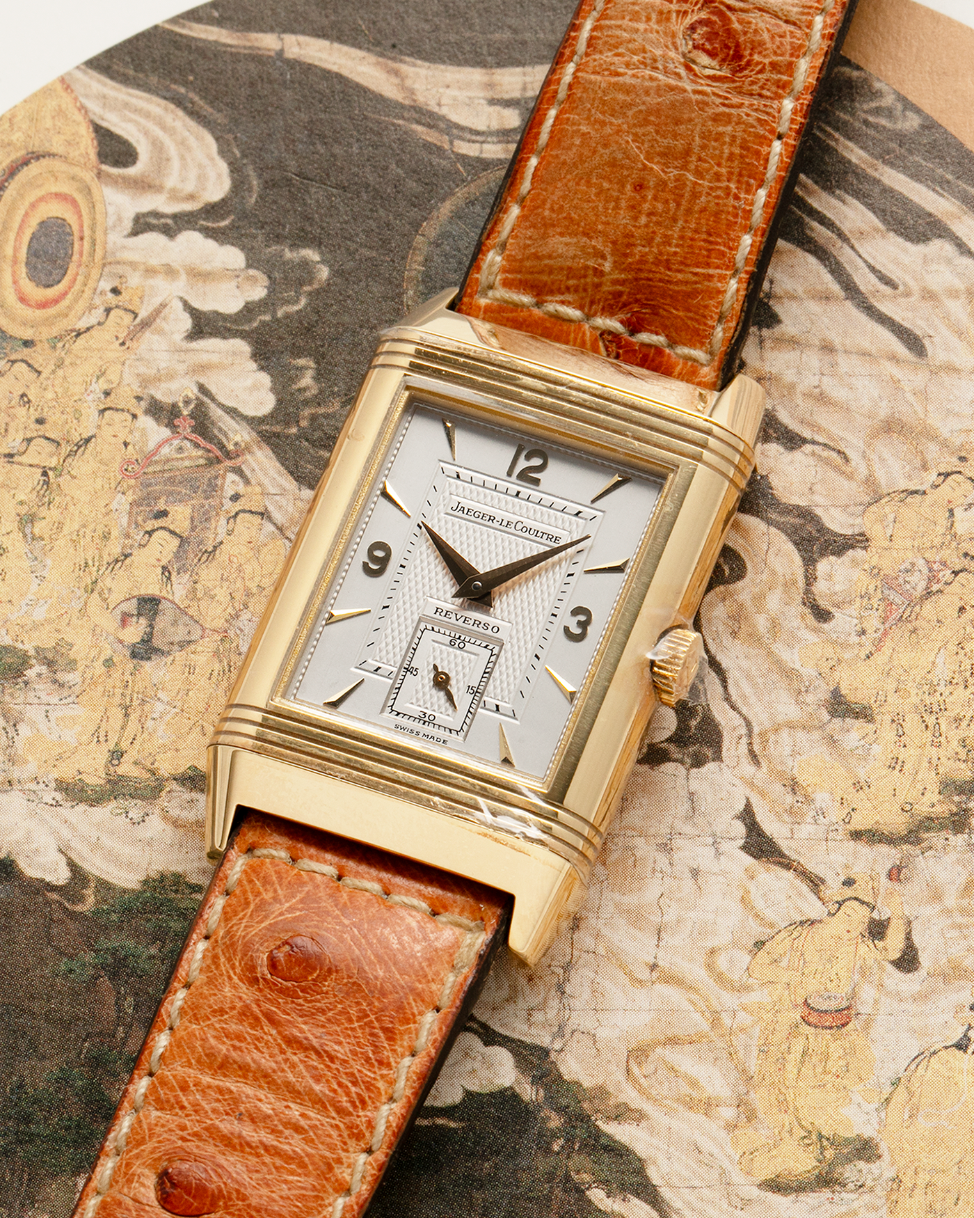 Brand: Jaeger LeCoultre
Year: 1995
Model: Reverso Geneva Fountain / Cathedral Saint-Pierre
Reference: 275.1.62 / 275.142.626 YG
Material: 18k Yellow Gold
Movement: Jaeger LeCoultre Cal. 852, Manual-Winding
Case Dimensions: 42mm X 26mm (10mm Thickness)
Lug Width: 19mm
Strap: Brown Jaeger-LeCoutre Ostrich Leather Strap with Jaeger-LeCoultre 18k Yellow Gold Tang Buckle