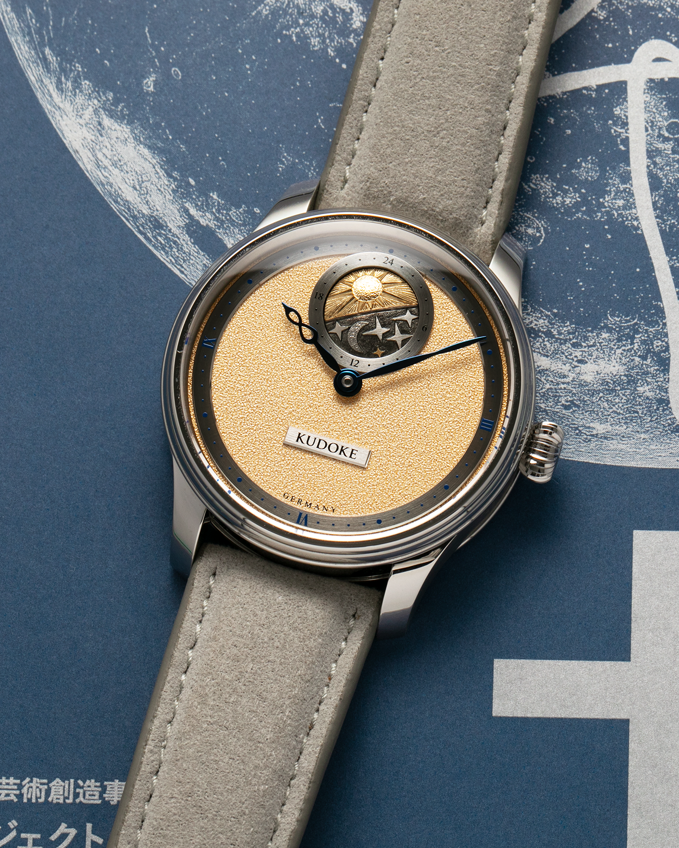 Brand: Kudoke Year: 2022 Model: Kudoke 2 ‘British Heritage’, Limited Edition of 30 pieces Material: Stainless Steel Movement: Kudoke Kaliber 1-24H, Manual-Winding Case Diameter: 39mm Lug Width: 20mm Strap: Kudoke Grey Alcantara Leather Strap with Signed Stainless Steel Tang Buckle, additional Dark Blue Alcantara Leather Strap