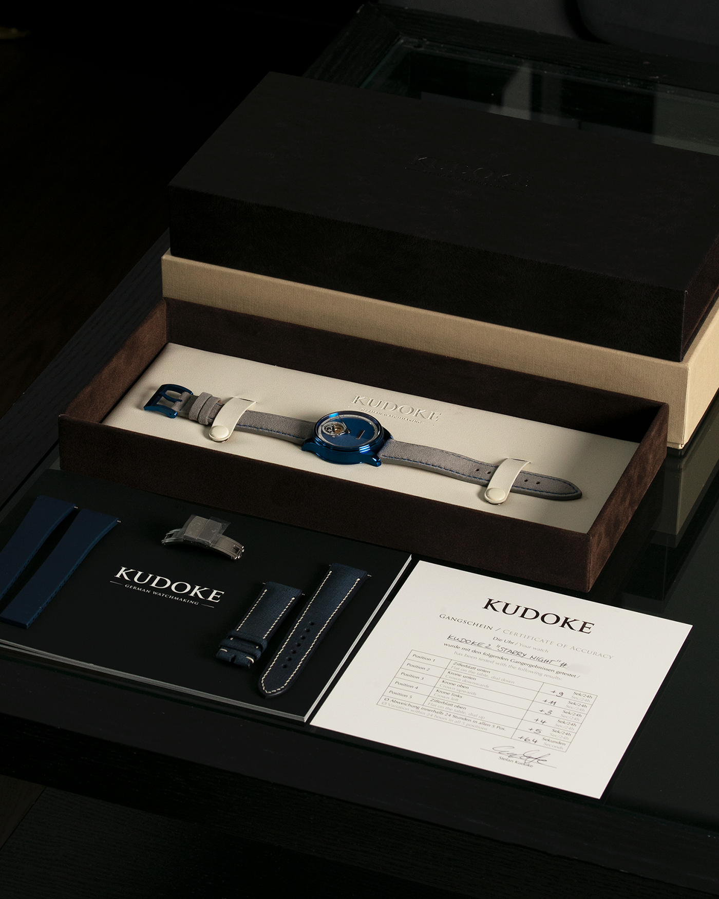 Brand: Kudoke Year: 2022 Model: Kudoke 2 ‘Starry Night’ Grail Watch 8, Limited Edition of 30 pieces Material: Grade 5 Titanium with CVD Blue Finish Movement: In-house Kaliber 1-24H, Manual-Winding Case Diameter: 39mm Strap: Grey Alcantara with Bovine Calf Lining and Blue Stitching with Signed CVD Blue Grade 5 Titanium Tang Buckle, Additional Delugs Navy CTS Rubber Strap, and Delugs Denim Bable Signature Strap