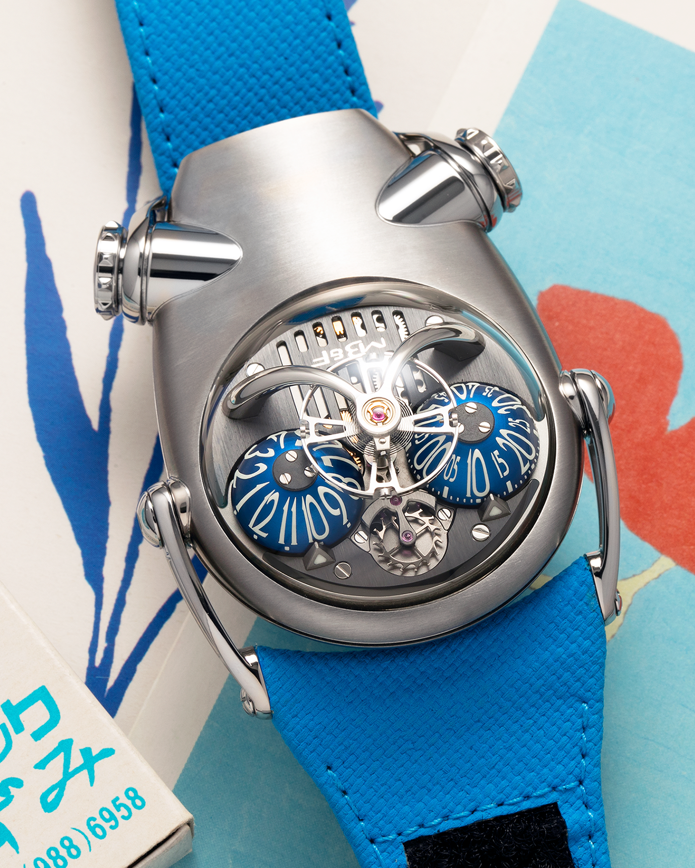 Brand: MB&F
Year: 2022
Model: HM10 ‘Bulldog’
Reference: 100.TL.BL
Material: Grade 5 Titanium
Movement: In-House Flying 14mm Balance Wheel with Four Floating Traditional Regulating Screws, Manual-Winding
Case Dimensions: 54mm (Including Lugs) x 45mm (Width) x 24mm (Height)
Strap: MB&F Proprietary Blue Calf Leather Velcro Strap with Signed Titanium Buckle