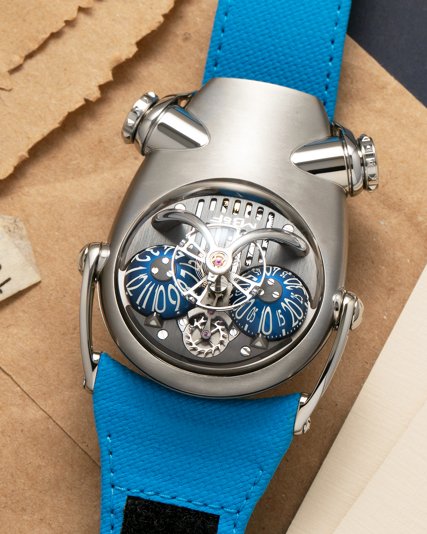 Brand: MB&F
Year: 2022
Model: HM10 ‘Bulldog’
Reference: 100.TL.BL
Material: Grade 5 Titanium
Movement: In-House Flying 14mm Balance Wheel with Four Floating Traditional Regulating Screws, Manual-Winding
Case Dimensions: 54mm (Including Lugs) x 45mm (Width) x 24mm (Height)
Strap: MB&F Proprietary Blue Calf Leather Velcro Strap with Signed Titanium Buckle