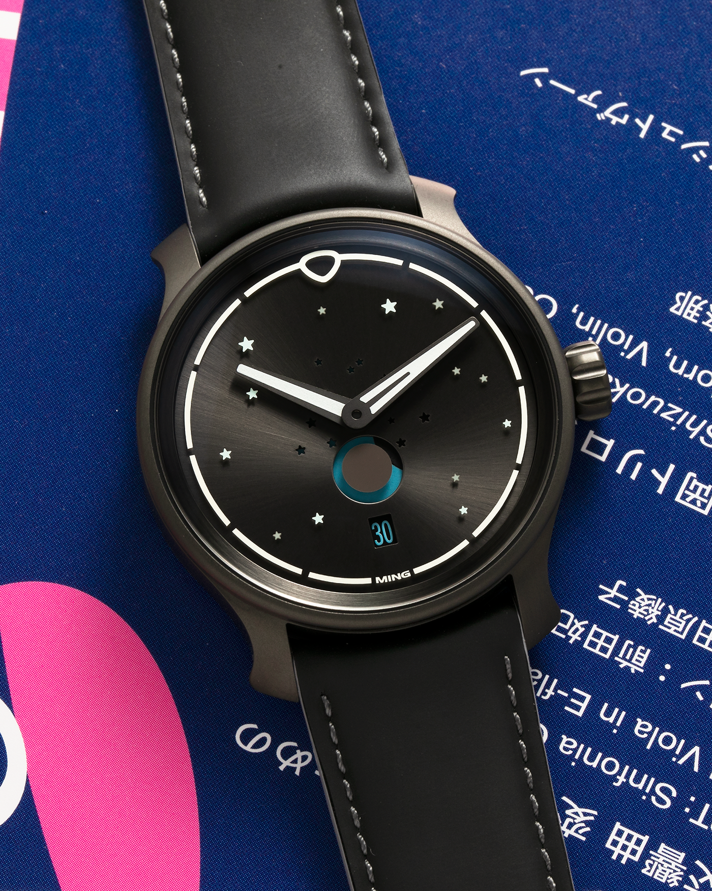 Brand: MING Year: 2023 Model: 37.05 Moonphase Series 2 Special Edition (Special Caves Project), Limited to 50 pieces Material: DLC-Coated Stainless Steel Movement: Heavily Modified Sellita Cal. SW288-1, Manual-Winding Case Diameter: 38mm Lug Width: 20mm Strap: Jean Rousseau Black Rubber with Blue Under Lining for MING with Signed DLC-Coated Keeperless Flying Blade Buckle