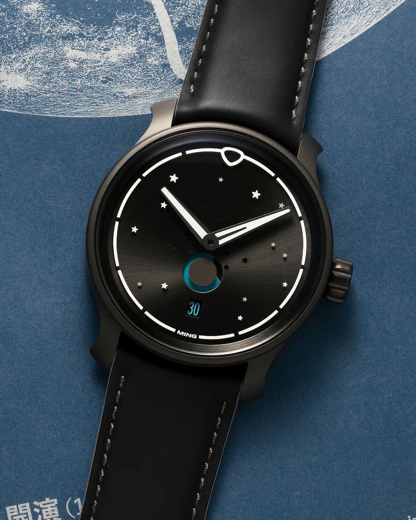 Brand: MING Year: 2023 Model: 37.05 Moonphase Series 2 Special Edition (Special Caves Project), Limited to 50 pieces Material: DLC-Coated Stainless Steel Movement: Heavily Modified Sellita Cal. SW288-1, Manual-Winding Case Diameter: 38mm Lug Width: 20mm Strap: Jean Rousseau Black Rubber with Blue Under Lining for MING with Signed DLC-Coated Keeperless Flying Blade Buckle