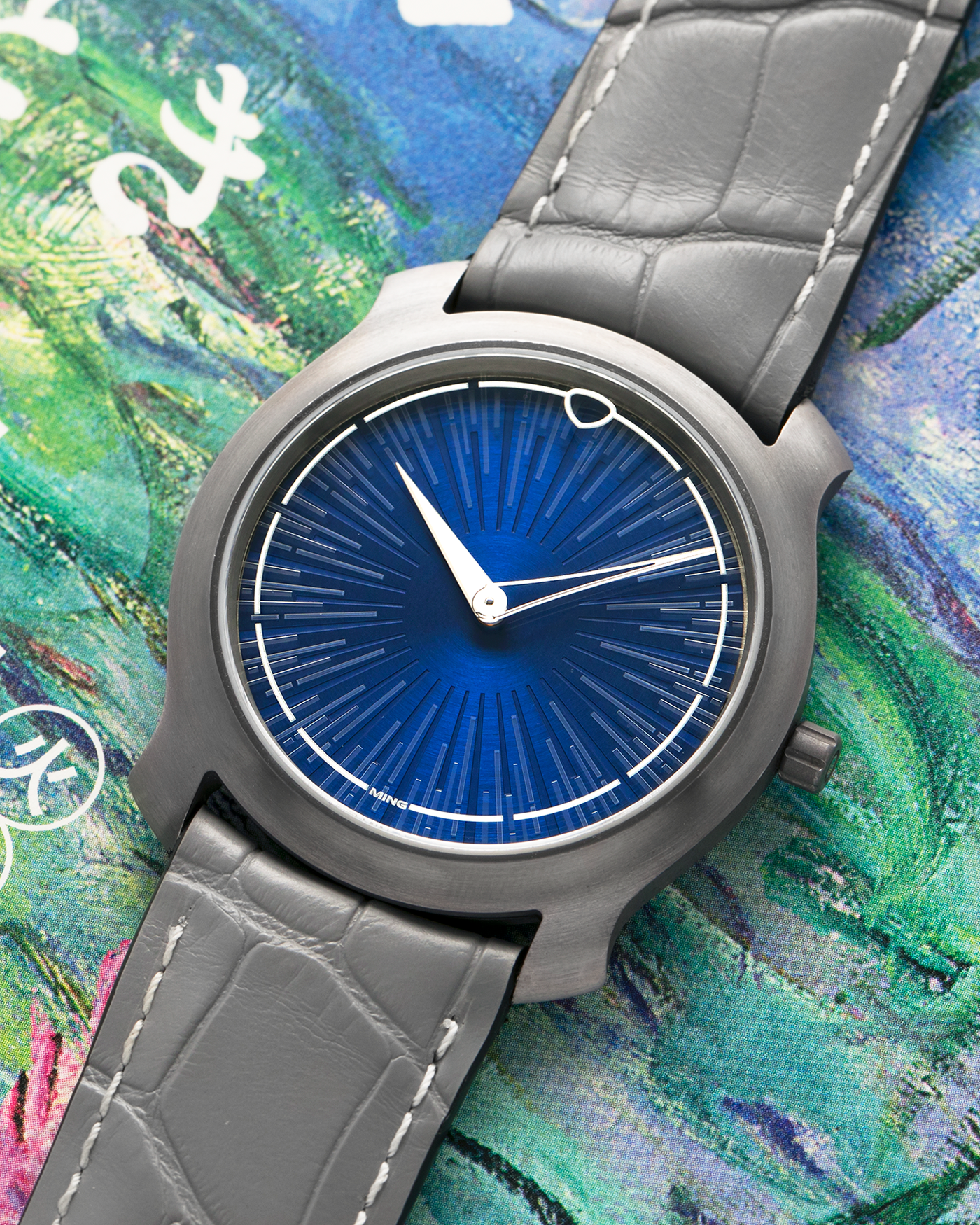 Brand: MING
Year: 2025
Model: Project 21 Souscription, Limited to 10 Pieces
Material: Tantalum Monobloc Case, FEMTOprint Borosilicate Crystal Dial, CVD-Coated Brass Dial Base
Movement: Heavily Modified Frederic Piguet Cal. 21, Manual-Winding
Case Dimensions: 35mm x 6.9mm (Lug-to-Lug 38.5mm)
Lug Width: 20mm
Strap: MING Dark Blue Alcantara Strap with Signed Tantalum Pin Buckle
