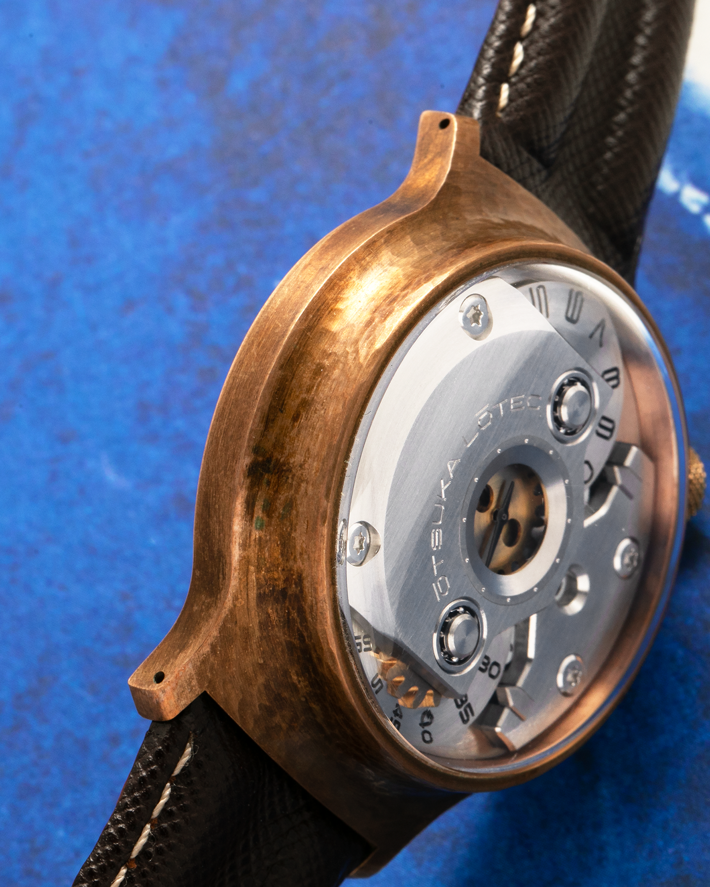 Brand: Otsuka Lotec
Year: 2020
Model: No.5 Bronze R-1 Reika
Material: Hand-Hammered Bronze with Stainless Steel Caseback
Movement: Modified Miyota Calibre 8215
Case Dimensions: 42mm Diameter 13.6mm Thickness
Strap: Brown Otsuka Lotec Leather Strap with Unsigned Otsuka Lotec Stainless Steel Tang Buckle