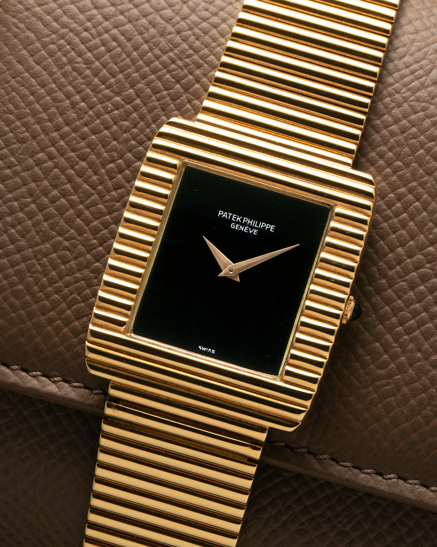 Brand: Patek Philippe
Year: 1976
Model: Gondolo
Reference Number: 3733J
Material: 18-carat Yellow Gold Case, Black Onyx Stone Dial
Movement: Patek Philippe Cal. 215, Manual-Winding
Case Dimensions: 29mm x 33mm (Including Lugs) x 6.5mm
Bracelet: Patek Philippe Ribbed Integrated Bracelet in 18-carat Yellow Gold with Signed Clasp