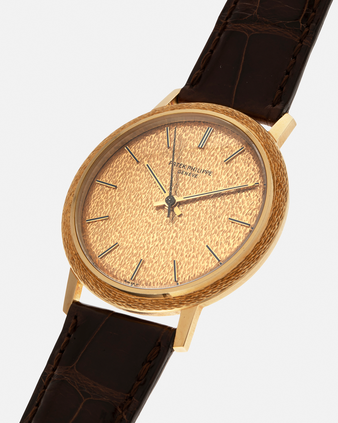 Brand: Patek Philippe
Year: 1970
Model: Calatrava ‘Back Wind’ Hammered
Reference Number: 3569J
Material: 18-carat Yellow Gold
Movement: Patek Philippe Back-Wind Cal. 350, Self-Winding
Case Dimensions: 36mm x 8.3mm (Lug-to-Lug 41mm)
Lug Width: 18mm
Strap: Patek Philippe Dark Brown Alligator Leather Strap with Signed 18-carat Yellow Gold Tang Buckle