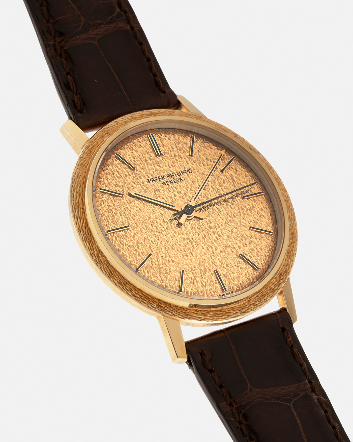 Brand: Patek Philippe
Year: 1970
Model: Calatrava ‘Back Wind’ Hammered
Reference Number: 3569J
Material: 18-carat Yellow Gold
Movement: Patek Philippe Back-Wind Cal. 350, Self-Winding
Case Dimensions: 36mm x 8.3mm (Lug-to-Lug 41mm)
Lug Width: 18mm
Strap: Patek Philippe Dark Brown Alligator Leather Strap with Signed 18-carat Yellow Gold Tang Buckle