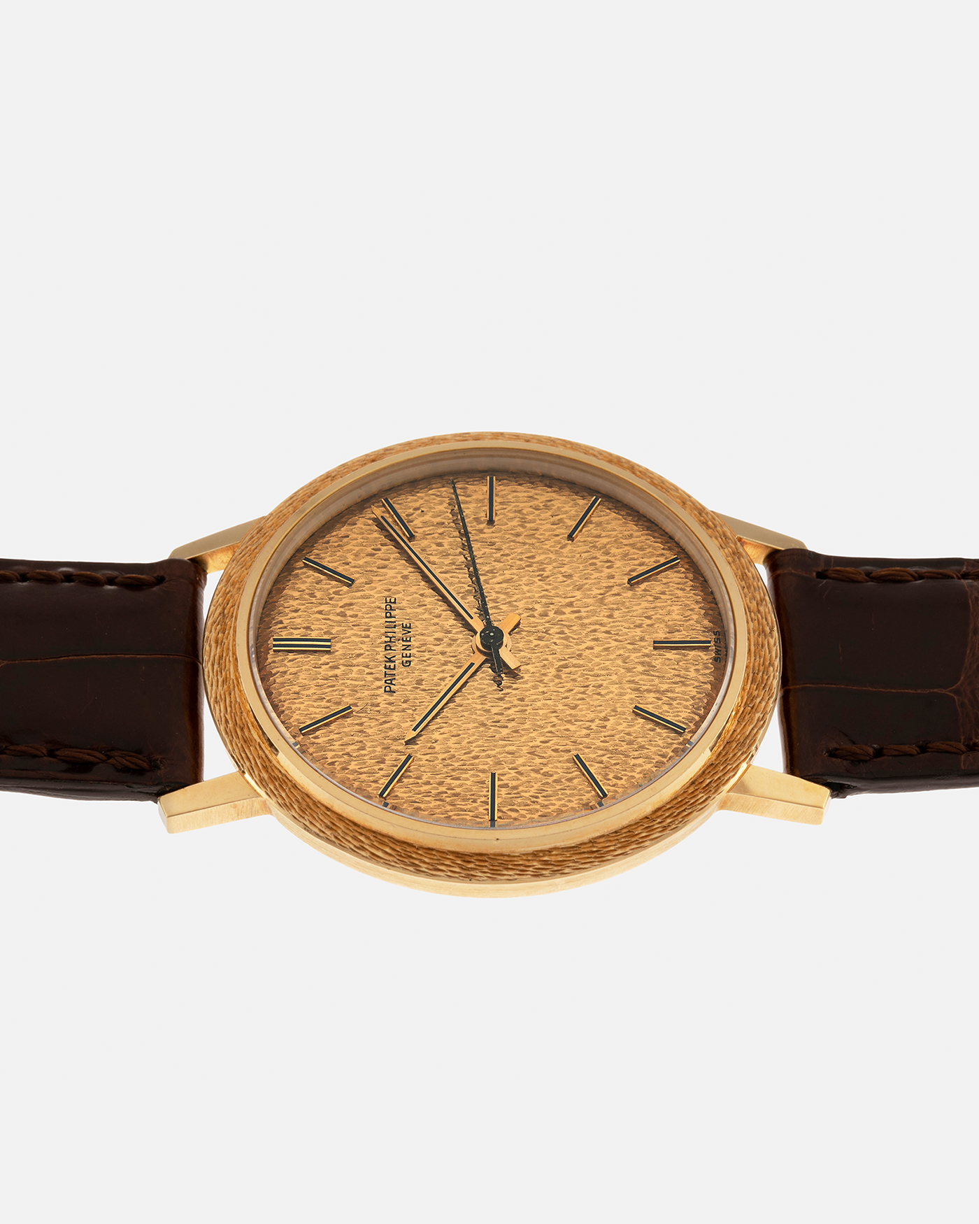Brand: Patek Philippe
Year: 1970
Model: Calatrava ‘Back Wind’ Hammered
Reference Number: 3569J
Material: 18-carat Yellow Gold
Movement: Patek Philippe Back-Wind Cal. 350, Self-Winding
Case Dimensions: 36mm x 8.3mm (Lug-to-Lug 41mm)
Lug Width: 18mm
Strap: Patek Philippe Dark Brown Alligator Leather Strap with Signed 18-carat Yellow Gold Tang Buckle