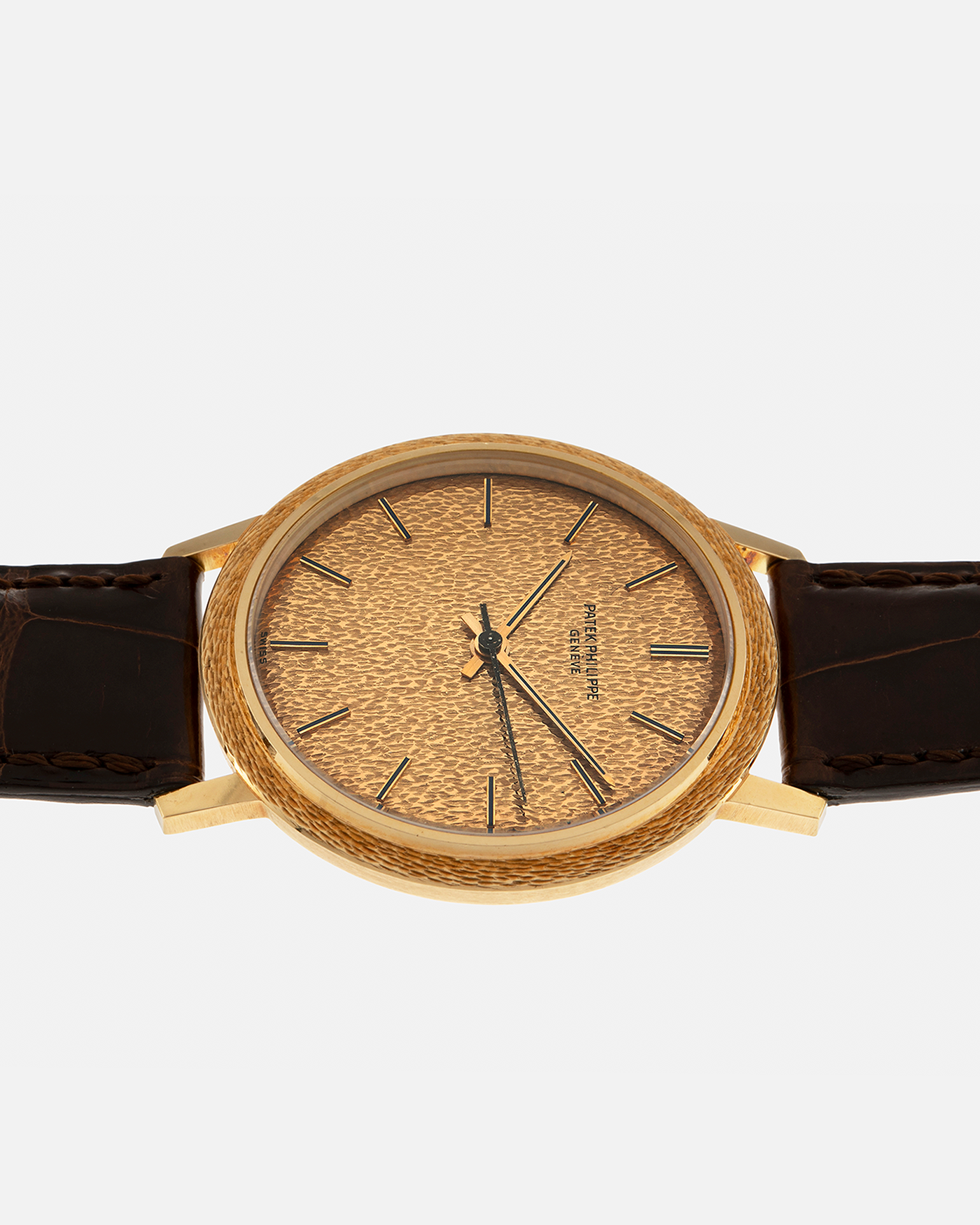 Brand: Patek Philippe
Year: 1970
Model: Calatrava ‘Back Wind’ Hammered
Reference Number: 3569J
Material: 18-carat Yellow Gold
Movement: Patek Philippe Back-Wind Cal. 350, Self-Winding
Case Dimensions: 36mm x 8.3mm (Lug-to-Lug 41mm)
Lug Width: 18mm
Strap: Patek Philippe Dark Brown Alligator Leather Strap with Signed 18-carat Yellow Gold Tang Buckle