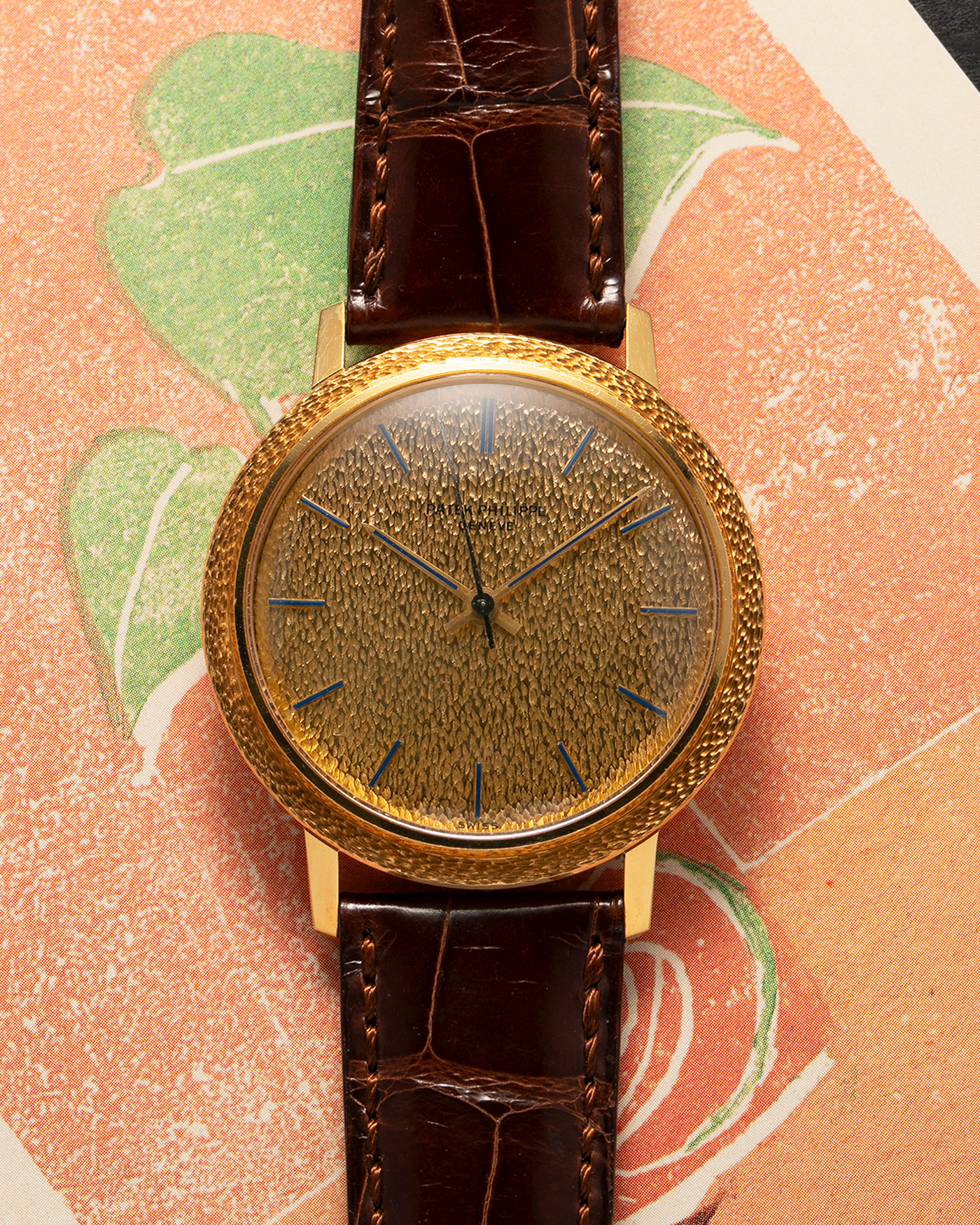 Brand: Patek Philippe
Year: 1970
Model: Calatrava ‘Back Wind’ Hammered
Reference Number: 3569J
Material: 18-carat Yellow Gold
Movement: Patek Philippe Back-Wind Cal. 350, Self-Winding
Case Dimensions: 36mm x 8.3mm (Lug-to-Lug 41mm)
Lug Width: 18mm
Strap: Patek Philippe Dark Brown Alligator Leather Strap with Signed 18-carat Yellow Gold Tang Buckle