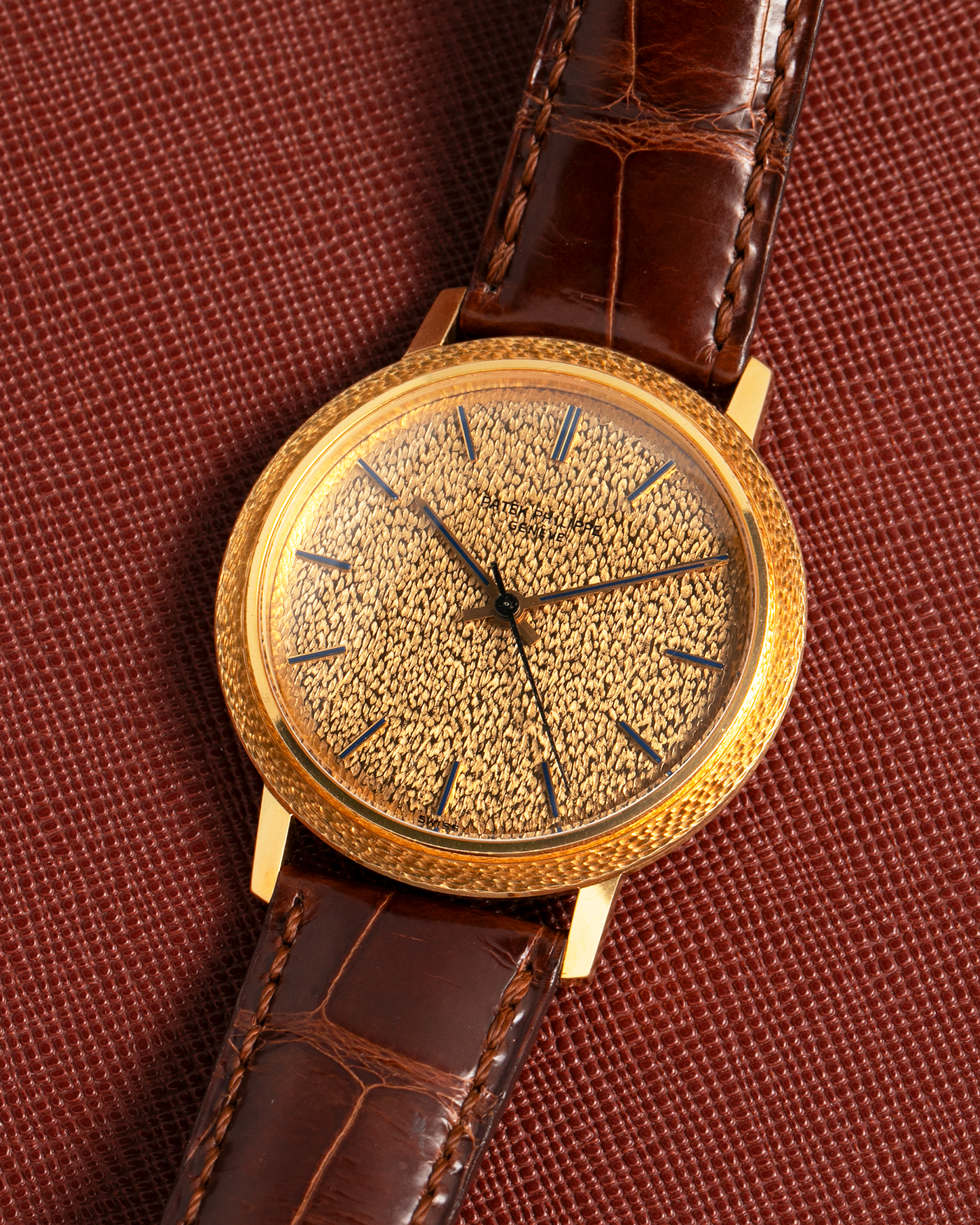 Brand: Patek Philippe
Year: 1970
Model: Calatrava ‘Back Wind’ Hammered
Reference Number: 3569J
Material: 18-carat Yellow Gold
Movement: Patek Philippe Back-Wind Cal. 350, Self-Winding
Case Dimensions: 36mm x 8.3mm (Lug-to-Lug 41mm)
Lug Width: 18mm
Strap: Patek Philippe Dark Brown Alligator Leather Strap with Signed 18-carat Yellow Gold Tang Buckle
