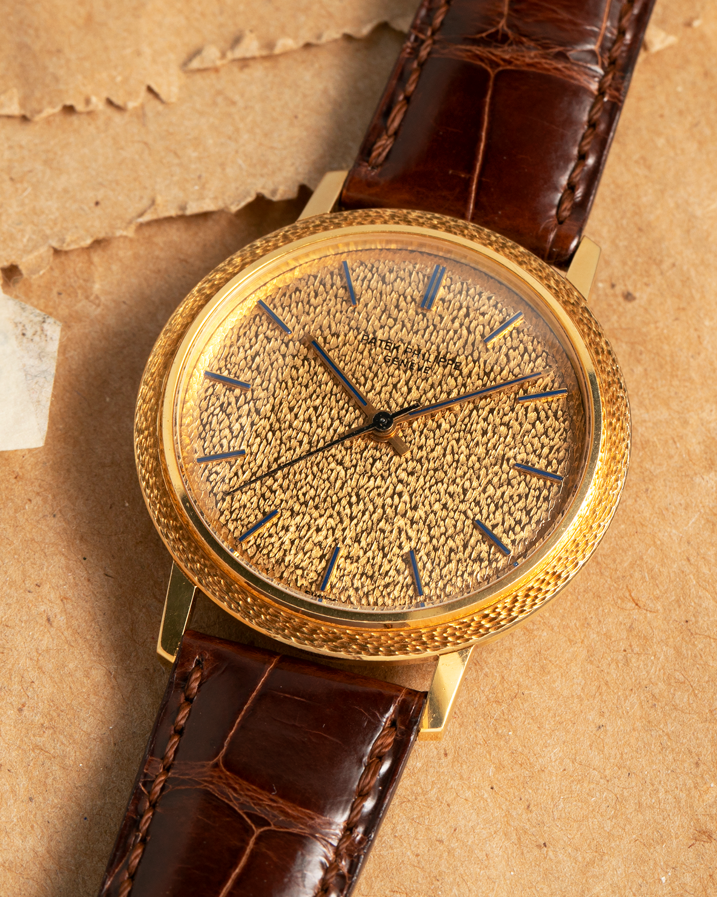 Brand: Patek Philippe
Year: 1970
Model: Calatrava ‘Back Wind’ Hammered
Reference Number: 3569J
Material: 18-carat Yellow Gold
Movement: Patek Philippe Back-Wind Cal. 350, Self-Winding
Case Dimensions: 36mm x 8.3mm (Lug-to-Lug 41mm)
Lug Width: 18mm
Strap: Patek Philippe Dark Brown Alligator Leather Strap with Signed 18-carat Yellow Gold Tang Buckle