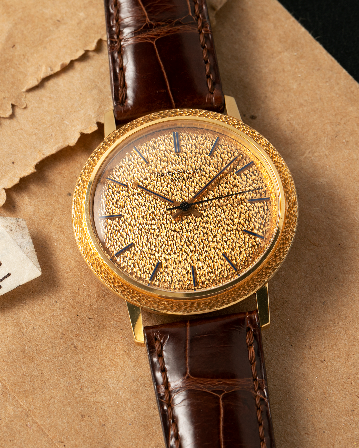 Brand: Patek Philippe
Year: 1970
Model: Calatrava ‘Back Wind’ Hammered
Reference Number: 3569J
Material: 18-carat Yellow Gold
Movement: Patek Philippe Back-Wind Cal. 350, Self-Winding
Case Dimensions: 36mm x 8.3mm (Lug-to-Lug 41mm)
Lug Width: 18mm
Strap: Patek Philippe Dark Brown Alligator Leather Strap with Signed 18-carat Yellow Gold Tang Buckle