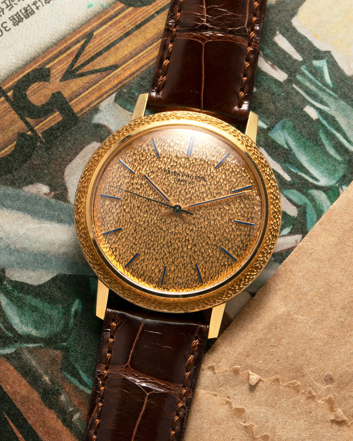 Brand: Patek Philippe
Year: 1970
Model: Calatrava ‘Back Wind’ Hammered
Reference Number: 3569J
Material: 18-carat Yellow Gold
Movement: Patek Philippe Back-Wind Cal. 350, Self-Winding
Case Dimensions: 36mm x 8.3mm (Lug-to-Lug 41mm)
Lug Width: 18mm
Strap: Patek Philippe Dark Brown Alligator Leather Strap with Signed 18-carat Yellow Gold Tang Buckle