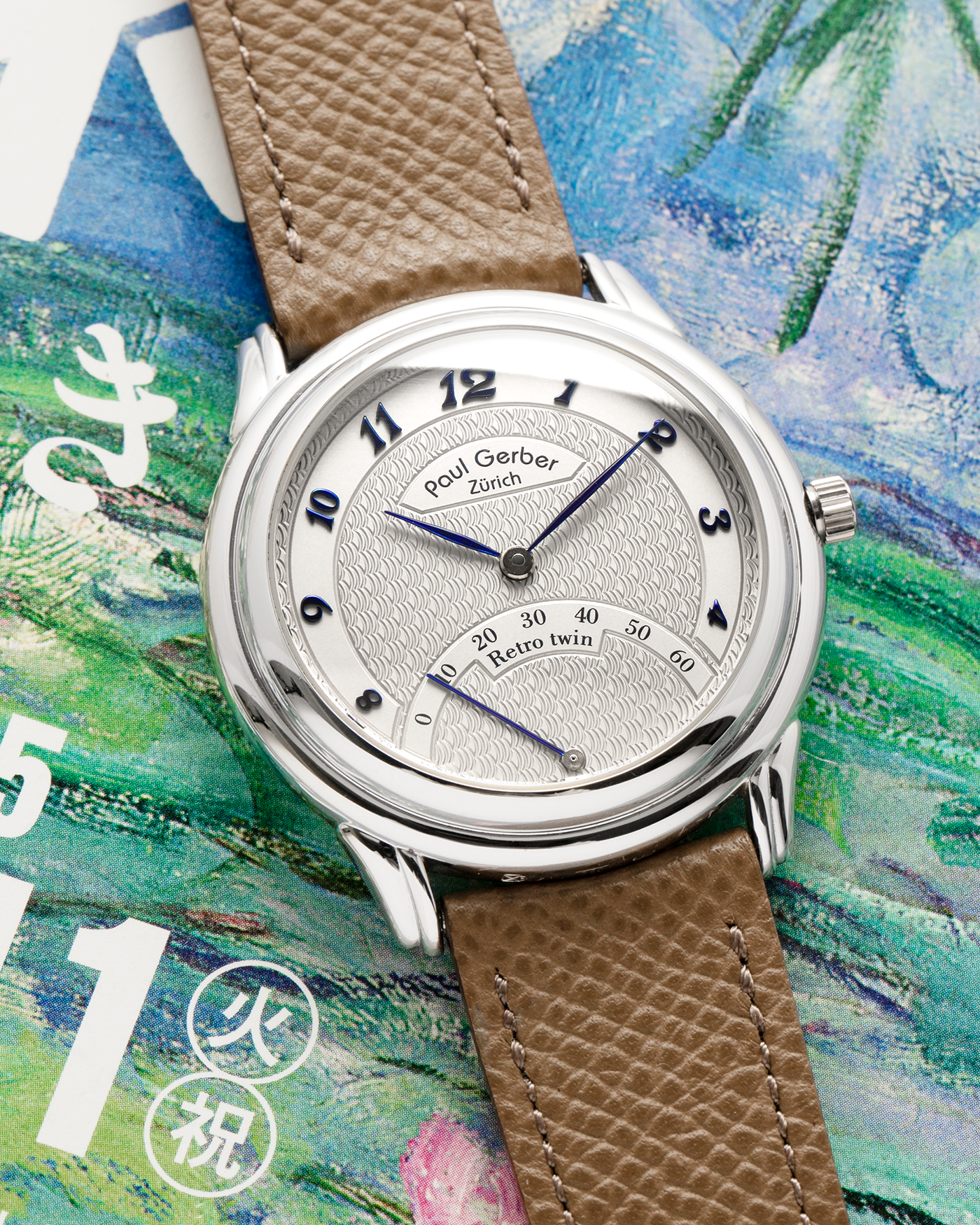 Brand: Paul Gerber
Year: 2000’s
Model: Retro Twin
Reference: 157
Material: 18-carat White Gold
Movement: Self-Winding Paul Gerber Cal. 15 (Heavily-Modified Peseux Cal. 7001)
Case Dimensions: 36mm Diameter 11mm Thickness
Lug Width: 18mm
Strap: Paul Gerber Dark Brown Calf Leather Strap with Signed 18-carat Yellow Gold Tang Buckle