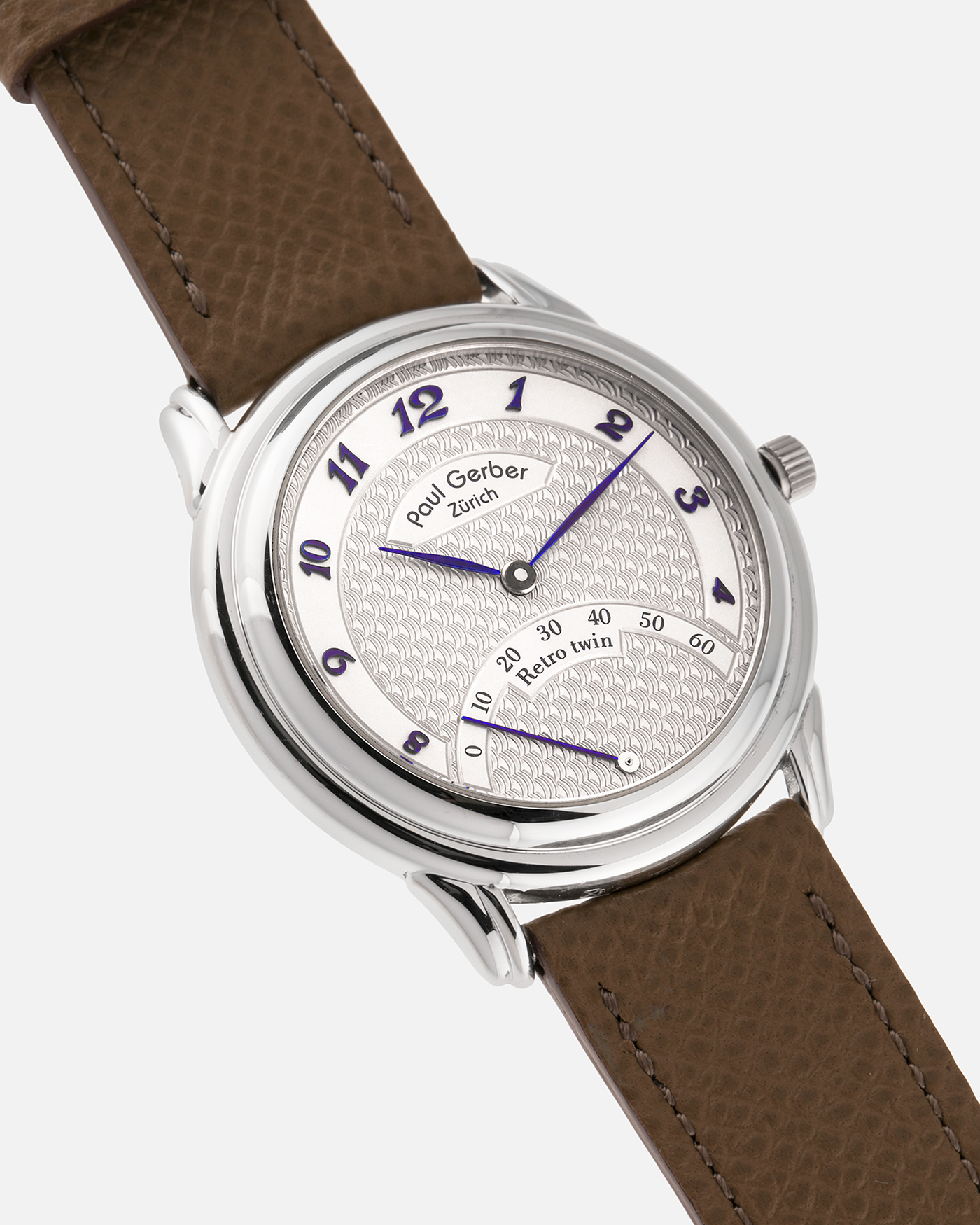 Brand: Paul Gerber
Year: 2000’s
Model: Retro Twin
Reference: 157
Material: 18-carat White Gold
Movement: Self-Winding Paul Gerber Cal. 15 (Heavily-Modified Peseux Cal. 7001)
Case Dimensions: 36mm Diameter 11mm Thickness
Lug Width: 18mm
Strap: Paul Gerber Dark Brown Calf Leather Strap with Signed 18-carat Yellow Gold Tang Buckle