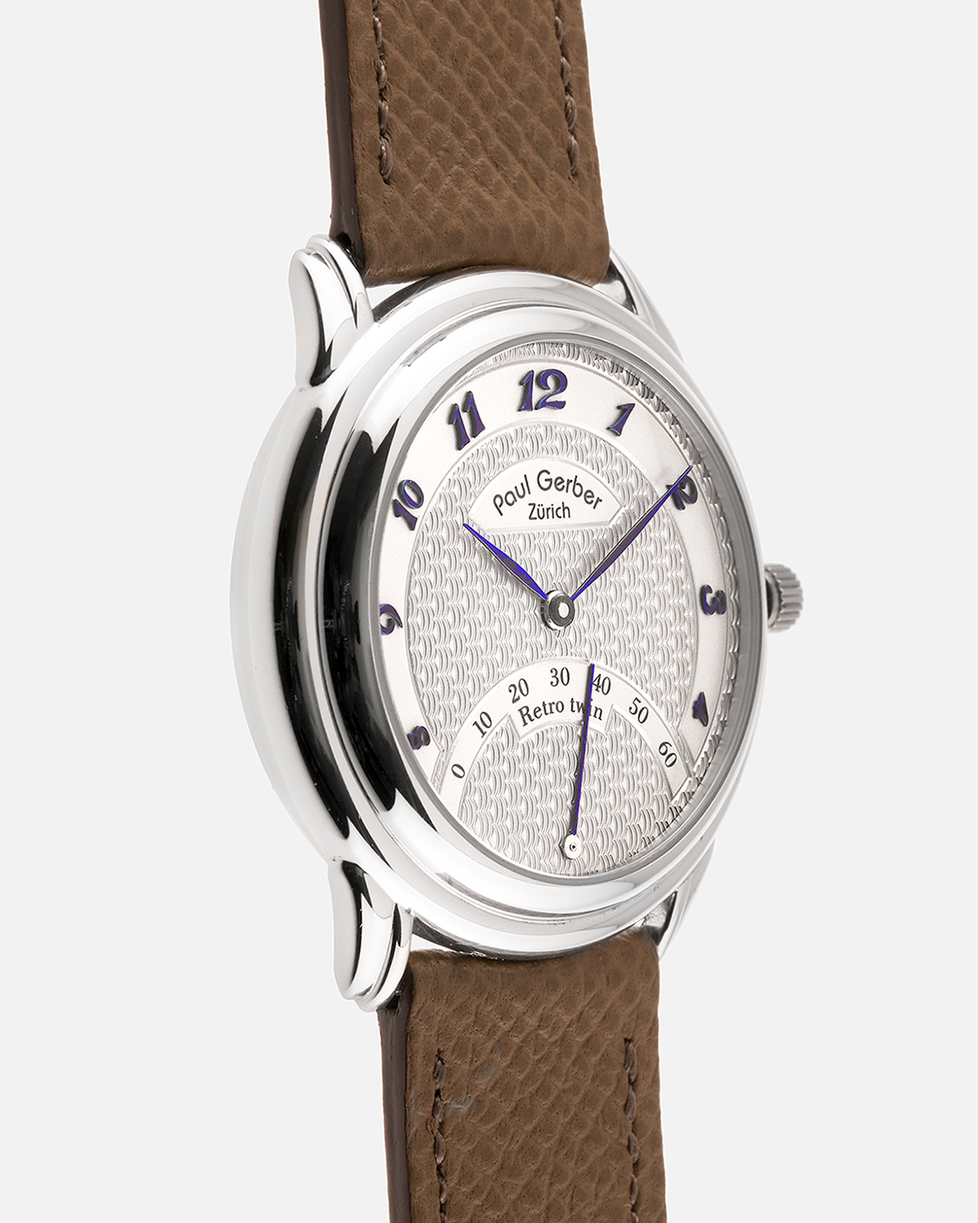 Brand: Paul Gerber
Year: 2000’s
Model: Retro Twin
Reference: 157
Material: 18-carat White Gold
Movement: Self-Winding Paul Gerber Cal. 15 (Heavily-Modified Peseux Cal. 7001)
Case Dimensions: 36mm Diameter 11mm Thickness
Lug Width: 18mm
Strap: Paul Gerber Dark Brown Calf Leather Strap with Signed 18-carat Yellow Gold Tang Buckle