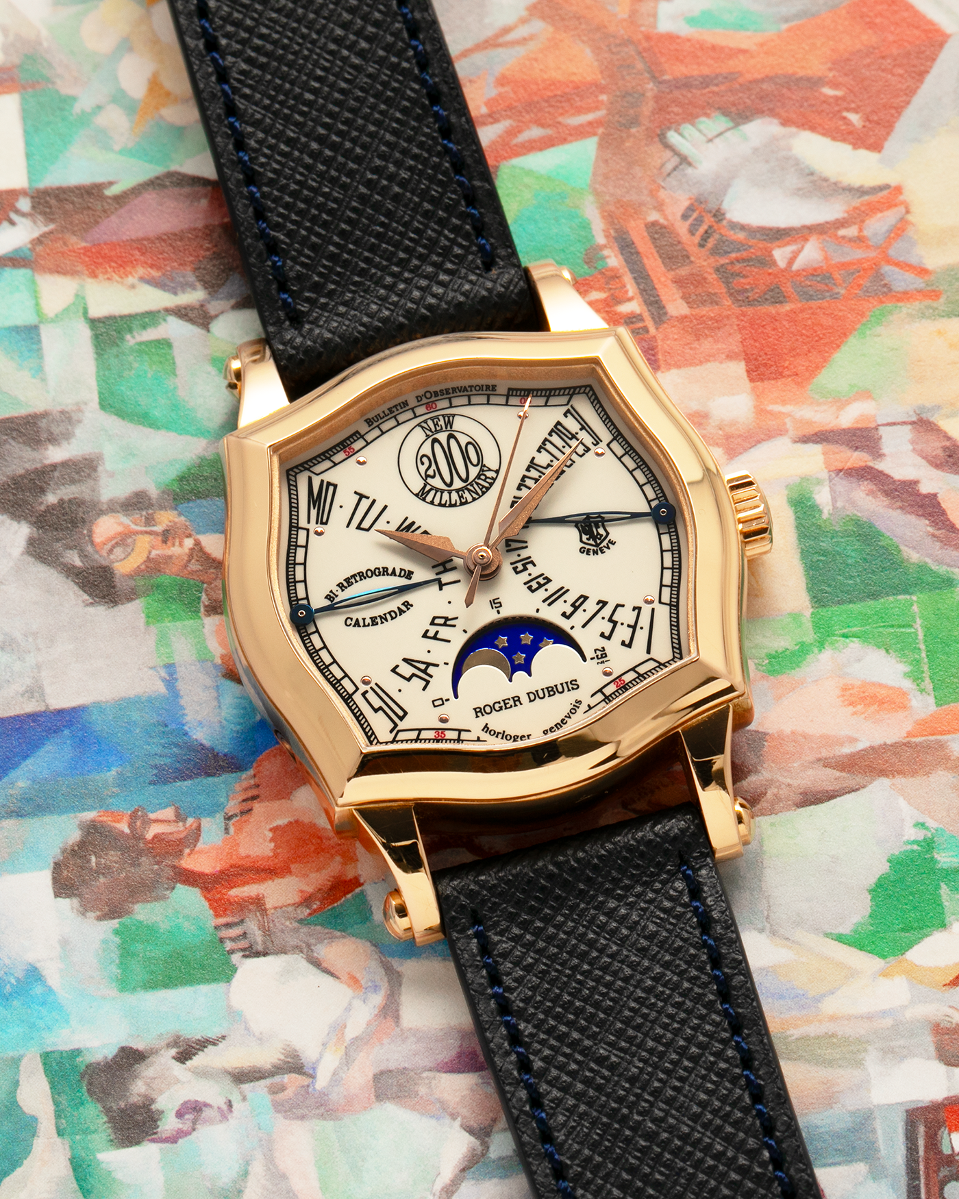 Brand: Roger Dubuis
Year: 2000
Model: Sympathie 37 2000 New Millenary
Material: 18k Rose Gold
Movement: Roger Dubuis Cal. 5740
Case Dimensions: 34mm Diameter 11mm Thickness
Lug Width: 18mm
Strap: Molequin Navy Blue Textured Calf Leather Strap with Signed 18k Rose Gold Tang Buckle