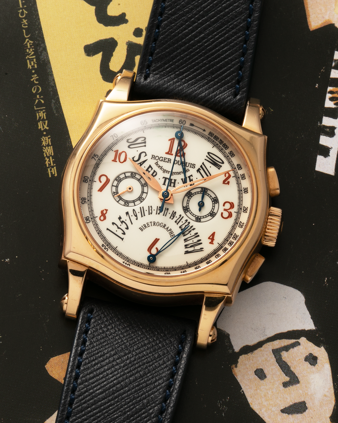 Brand: Roger Dubuis Year: 2000’s Model: Sympathie 40 Biretrograde Chronograph Material: 18-carat Yellow Gold Movement: Roger Dubuis Cal. RD 5630 (Based on the Lemania Cal. 2310), Manual-Winding Case Diameter: 40mm Strap: Molequin Navy Blue Textured Calf Leather Strap with Signed 18-carat Yellow Gold Roger Dubuis Tang Buckle
