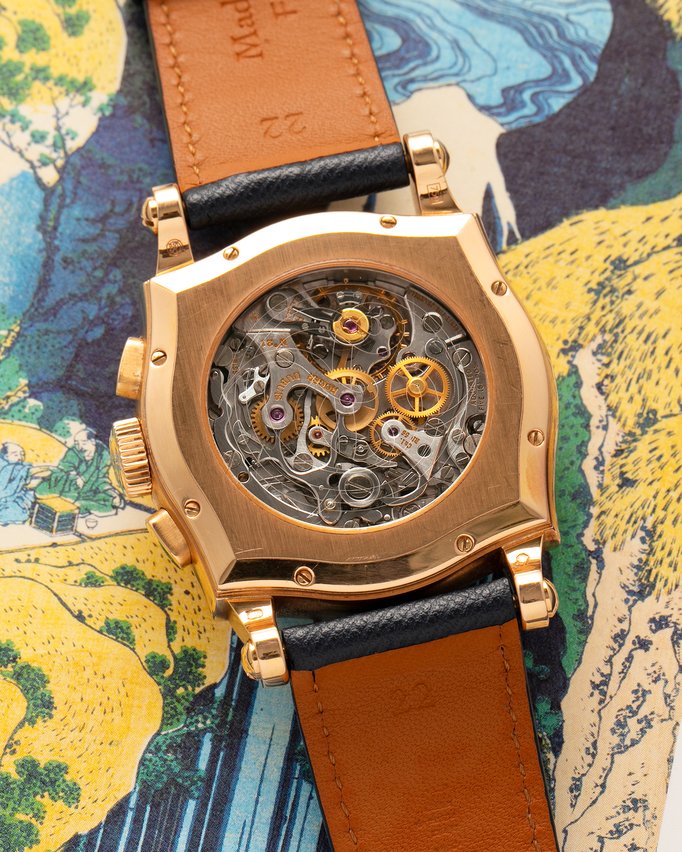 Brand: Roger Dubuis
Year: 2000s
Model: Sympathie 40 Biretrograde Chronograph
Material: 18-carat Yellow Gold
Movement: Roger Dubuis Cal. RD 5630 (Based on the Lemania Cal. 2310), Manual-Winding
Case Dimensions: 40mm x 12.25mm (Lug-to-Lug 47mm)
Lug Width: 22mm
Strap: Molequin Navy Blue Textured Calf Leather Strap with Signed 18-carat Yellow Gold Tang Buckle