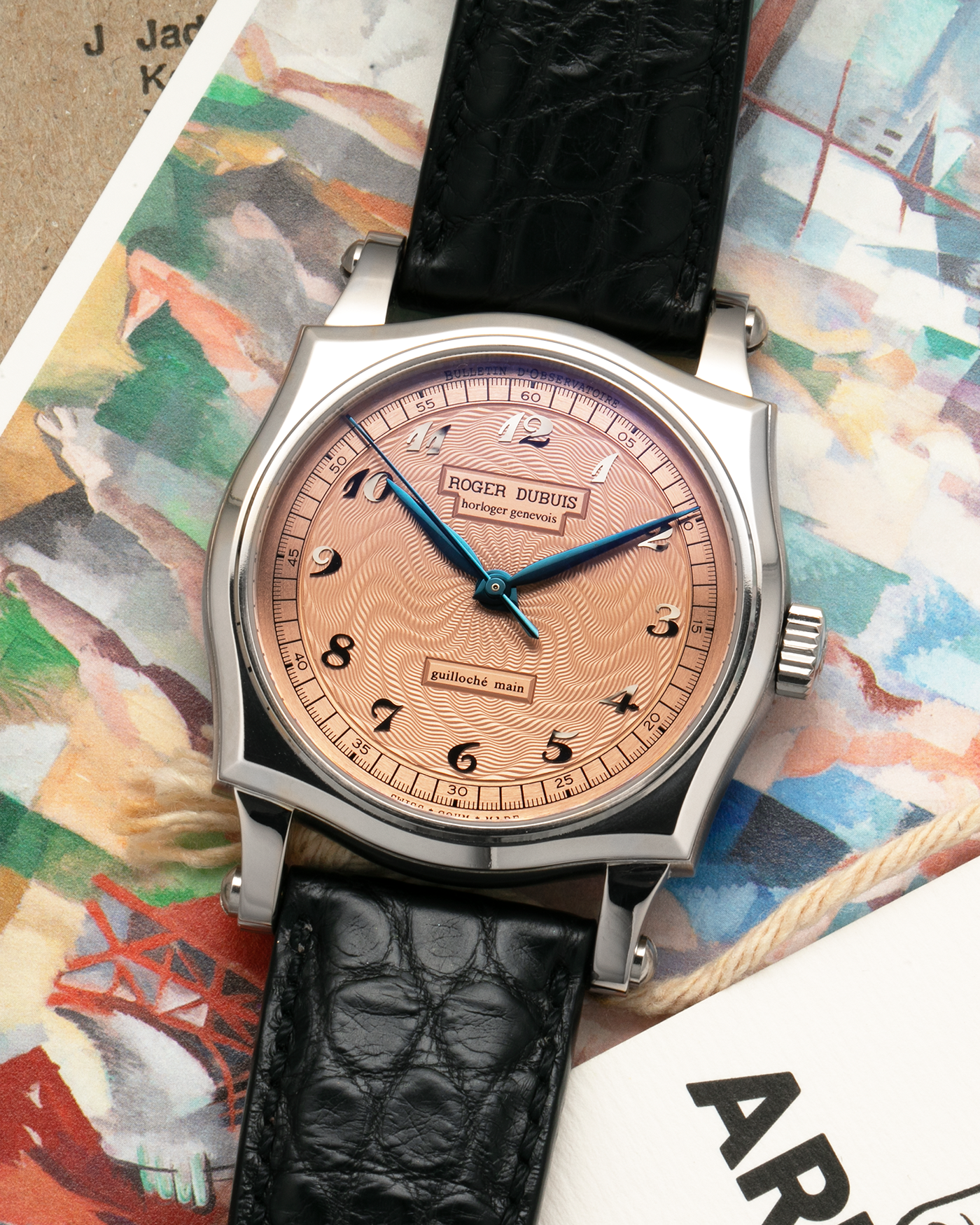 Brand: Roger Dubuis
Year: 2001
Model: Sympathie 37 ‘Salmon Guilloché’, Limited to 28 Pieces
Reference: S37.57.0
Material: 18-carat White Gold
Movement: Roger Dubuis Cal. RD 57, Self-Winding
Case Dimensions: 37mm x 8.5mm (Lug-to-Lug 46.5mm)
Lug Width: 20mm
Strap: Roger Dubuis Black Crocodile Leather Strap with Signed 18-carat White Gold Tang Buckle