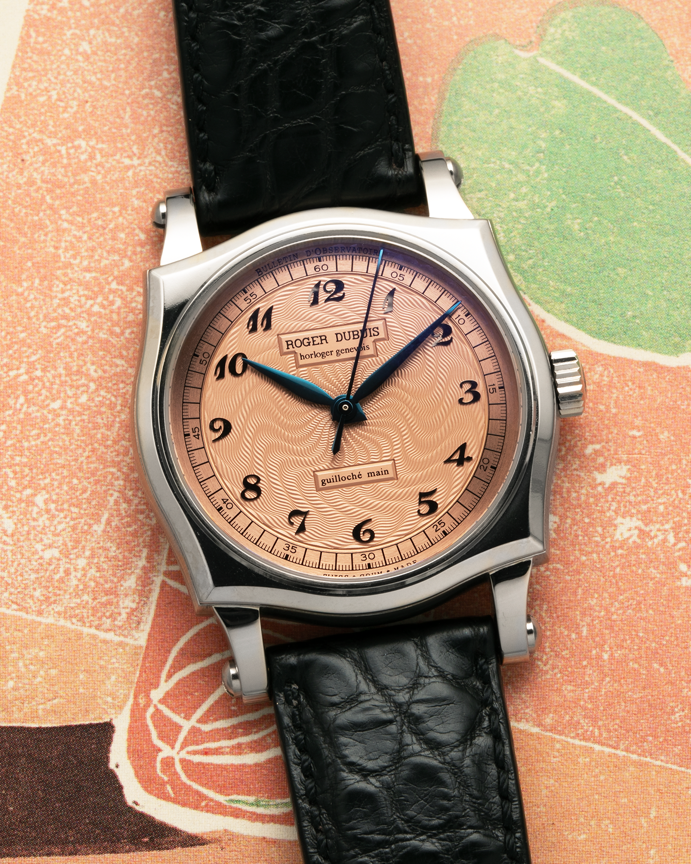 Brand: Roger Dubuis
Year: 2001
Model: Sympathie 37 ‘Salmon Guilloché’, Limited to 28 Pieces
Reference: S37.57.0
Material: 18-carat White Gold
Movement: Roger Dubuis Cal. RD 57, Self-Winding
Case Dimensions: 37mm x 8.5mm (Lug-to-Lug 46.5mm)
Lug Width: 20mm
Strap: Roger Dubuis Black Crocodile Leather Strap with Signed 18-carat White Gold Tang Buckle