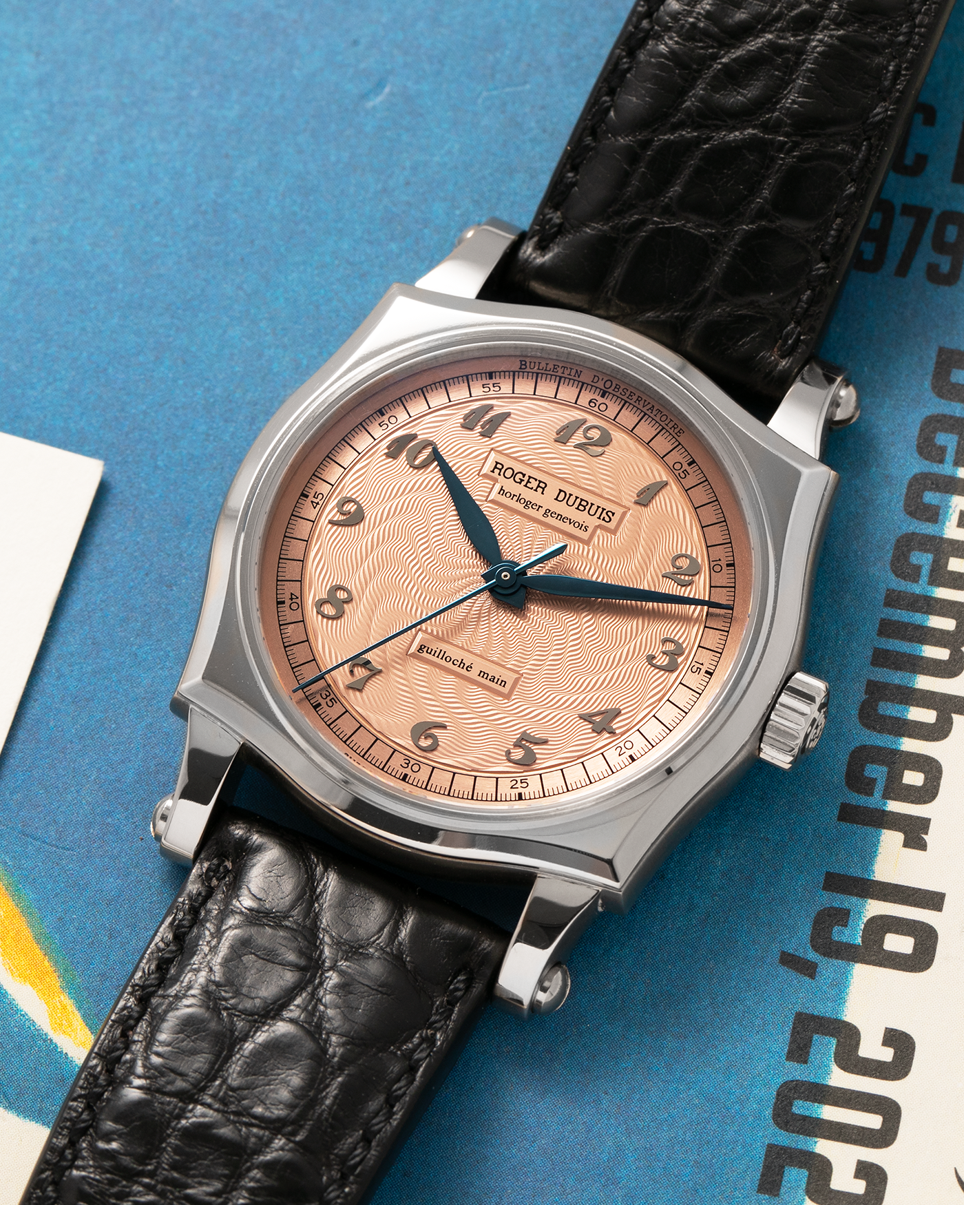 Brand: Roger Dubuis
Year: 2001
Model: Sympathie 37 ‘Salmon Guilloché’, Limited to 28 Pieces
Reference: S37.57.0
Material: 18-carat White Gold
Movement: Roger Dubuis Cal. RD 57, Self-Winding
Case Dimensions: 37mm x 8.5mm (Lug-to-Lug 46.5mm)
Lug Width: 20mm
Strap: Roger Dubuis Black Crocodile Leather Strap with Signed 18-carat White Gold Tang Buckle