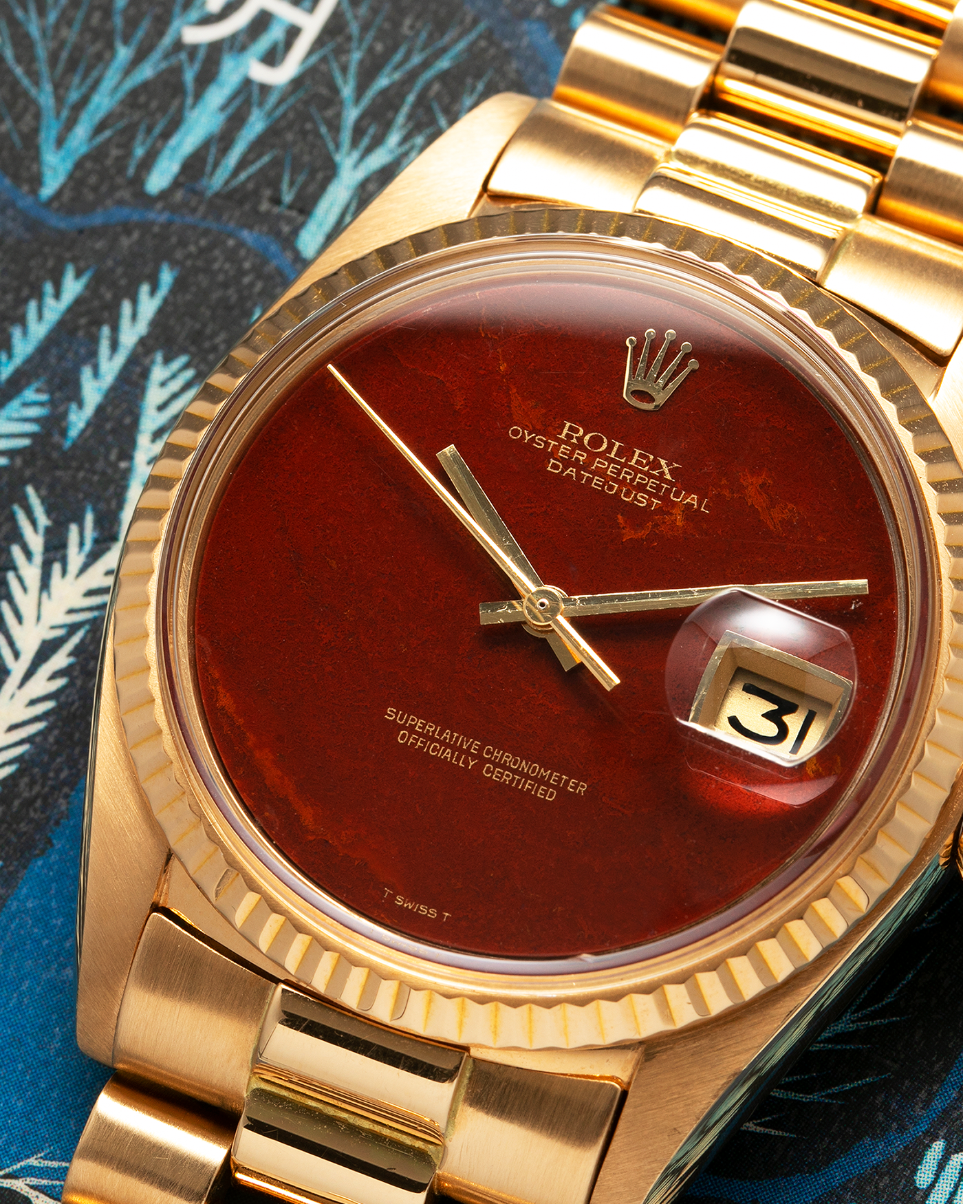 Brand: Rolex Year: 1975 Model: Datejust Reference Number: 1601/8 Serial Number: 392XXXX Material: 18-carat Yellow Gold, Red Jasper Stone Dial Movement: Rolex Cal. 1565, Self-Winding Case Diameter: 36mm Lug Width: 20mm Bracelet: Rolex 18-carat Yellow Gold 8385 Presidential Bracelet with 55B Curved End Links