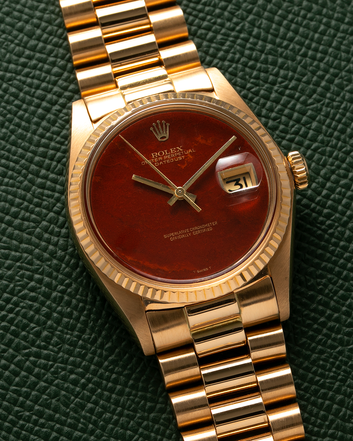 Brand: Rolex Year: 1975 Model: Datejust Reference Number: 1601/8 Serial Number: 392XXXX Material: 18-carat Yellow Gold, Red Jasper Stone Dial Movement: Rolex Cal. 1565, Self-Winding Case Diameter: 36mm Lug Width: 20mm Bracelet: Rolex 18-carat Yellow Gold 8385 Presidential Bracelet with 55B Curved End Links