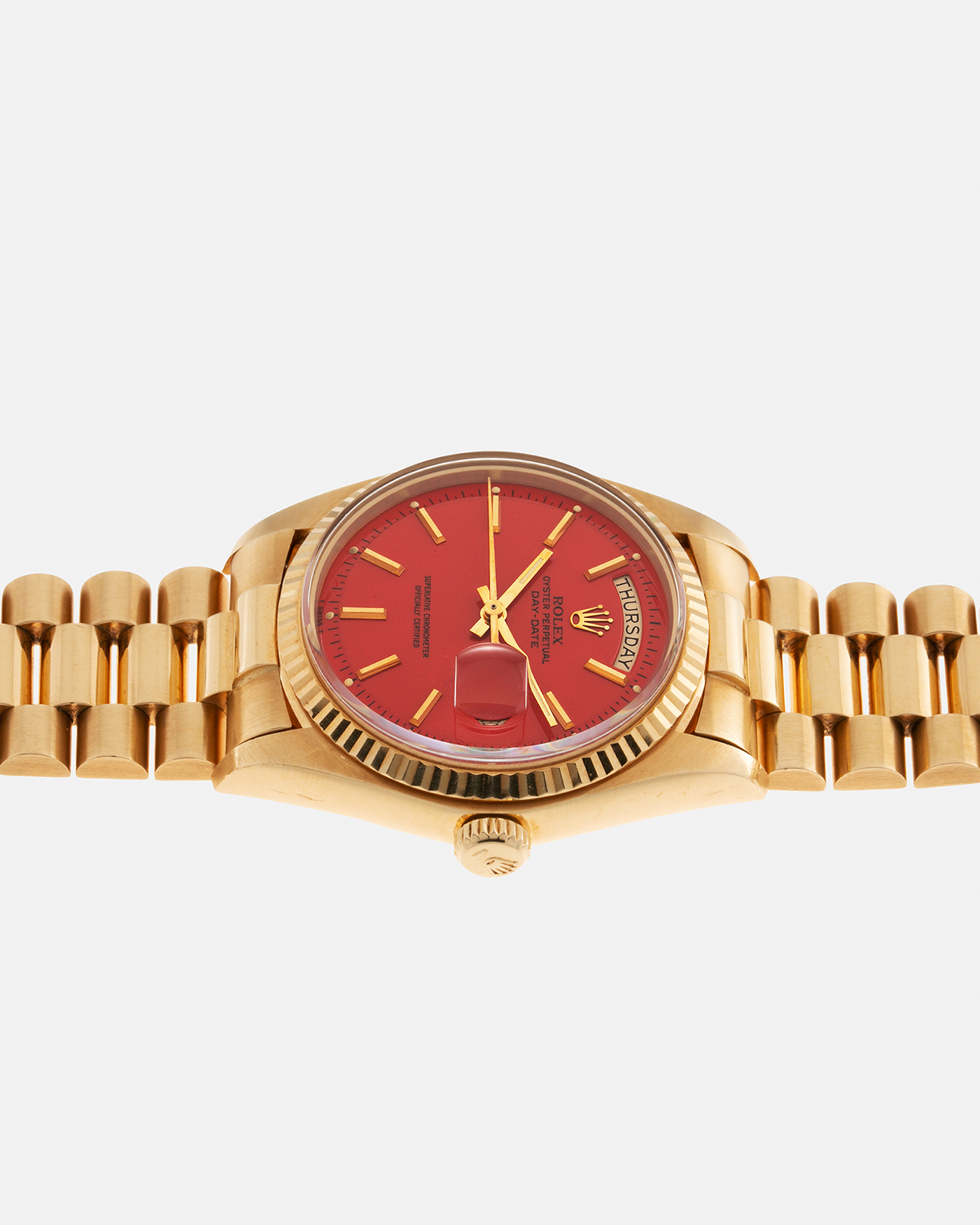 Brand: Rolex Year: 1978 Model: Day-Date, Coral Red ‘Stella’ Reference Number: 1803 Serial: 510XXXX Material: 18-carat Yellow Gold Movement: Rolex Cal. 1556, Self-Winding Case Diameter: 36mm Lug Width: 20mm Bracelet: Rolex 18-carat Yellow Gold ‘F18000’ Stamped Presidential Bracelet with ‘55’ Curved End Links