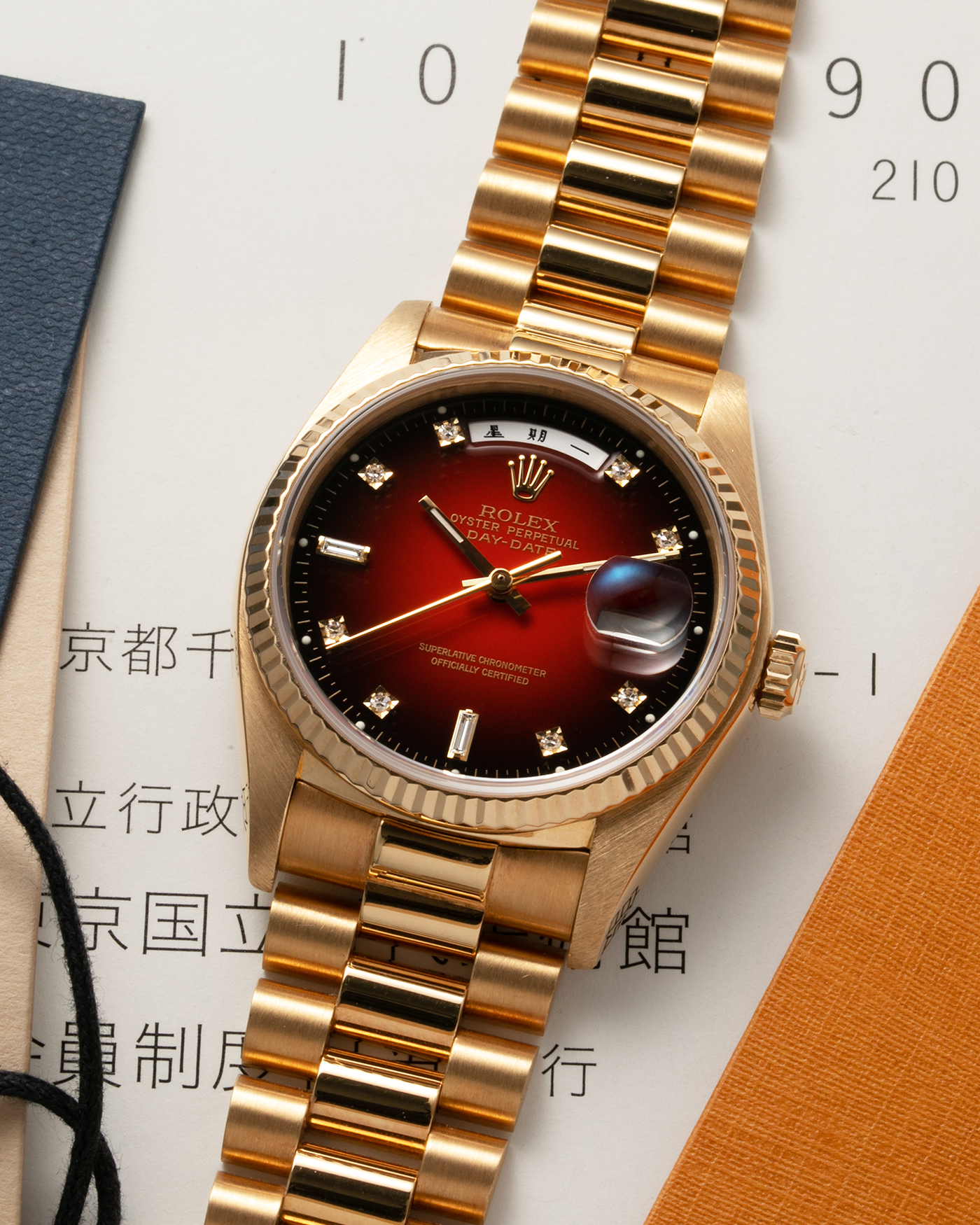 Brand: Rolex Year: 1979 Serial Number: 626XXXX Model: Day Date, Red Vignette Lacquer Dial, Chinese Day and Date Discs Reference Number: 18038 Material: 18-carat Yellow Gold Movement: Cal. 3055, Self-Winding Case Diameter: 36mm Lug Width: 20mm Bracelet: Rolex 8385 18-carat Yellow Gold Presidential Bracelet