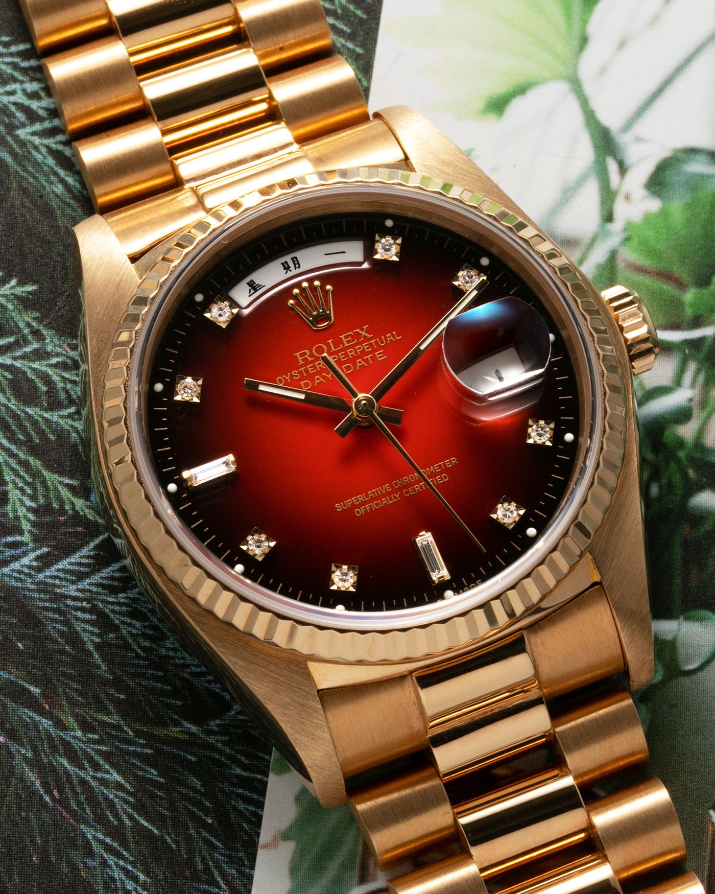 Brand: Rolex Year: 1979 Serial Number: 626XXXX Model: Day Date, Red Vignette Lacquer Dial, Chinese Day and Date Discs Reference Number: 18038 Material: 18-carat Yellow Gold Movement: Cal. 3055, Self-Winding Case Diameter: 36mm Lug Width: 20mm Bracelet: Rolex 8385 18-carat Yellow Gold Presidential Bracelet