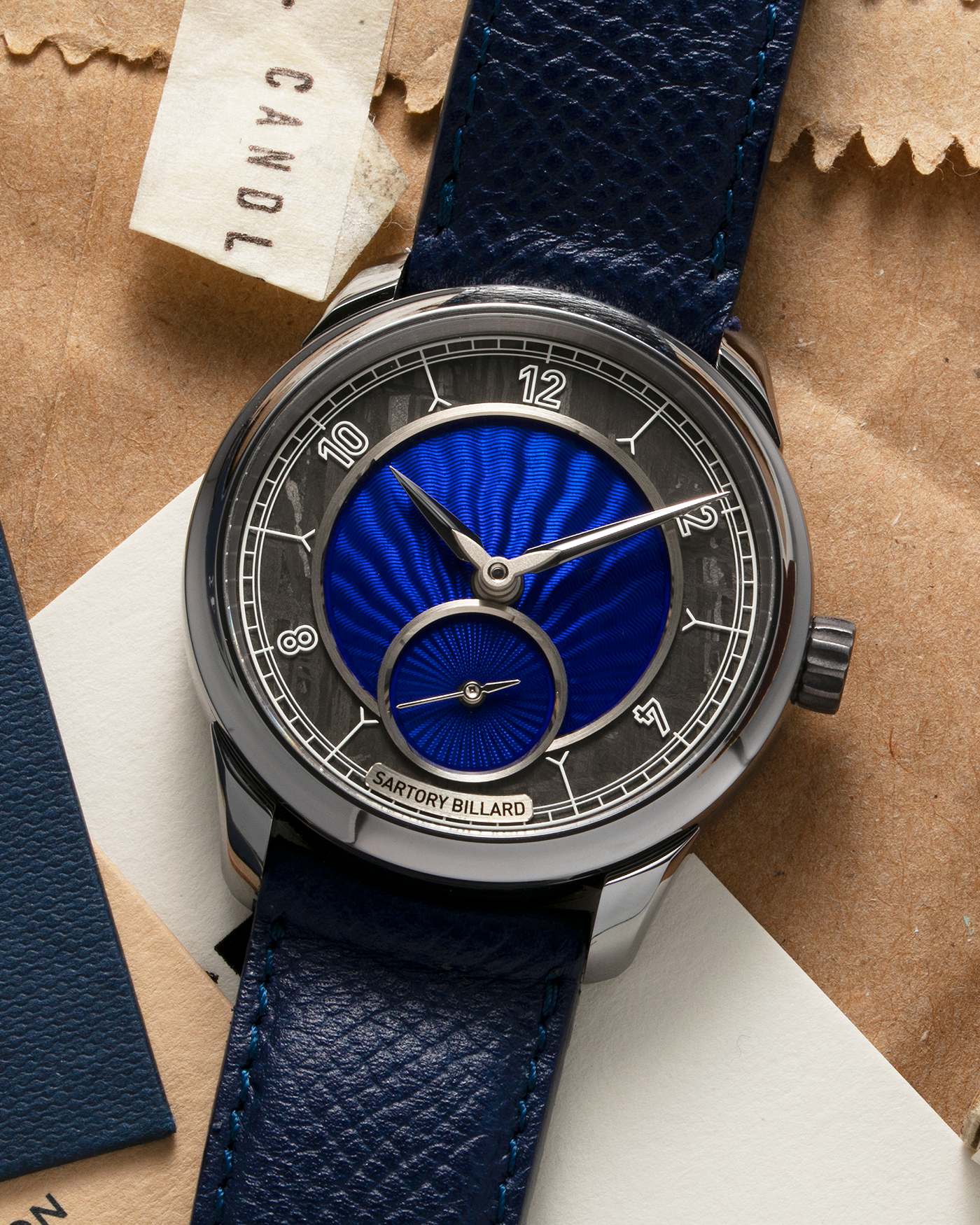 Brand: Sartory Billard Year: 2023 Model: SB05 Material: Tantalum Case, Meteorite Chapter Ring Movement: La Joux-Perret Cal. 7380, Manual-Winding  Case Diameter: 38.5mm Strap: Sartory Billard Dark Blue Textured Calf Leather Strap with Sartory Billard Signature Tang Buckle, with an additional Sartory Billard Veal Hermeline Strap and a Calf Suede Strap, both additional straps with Sartory Billard Signature Tang Buckles
