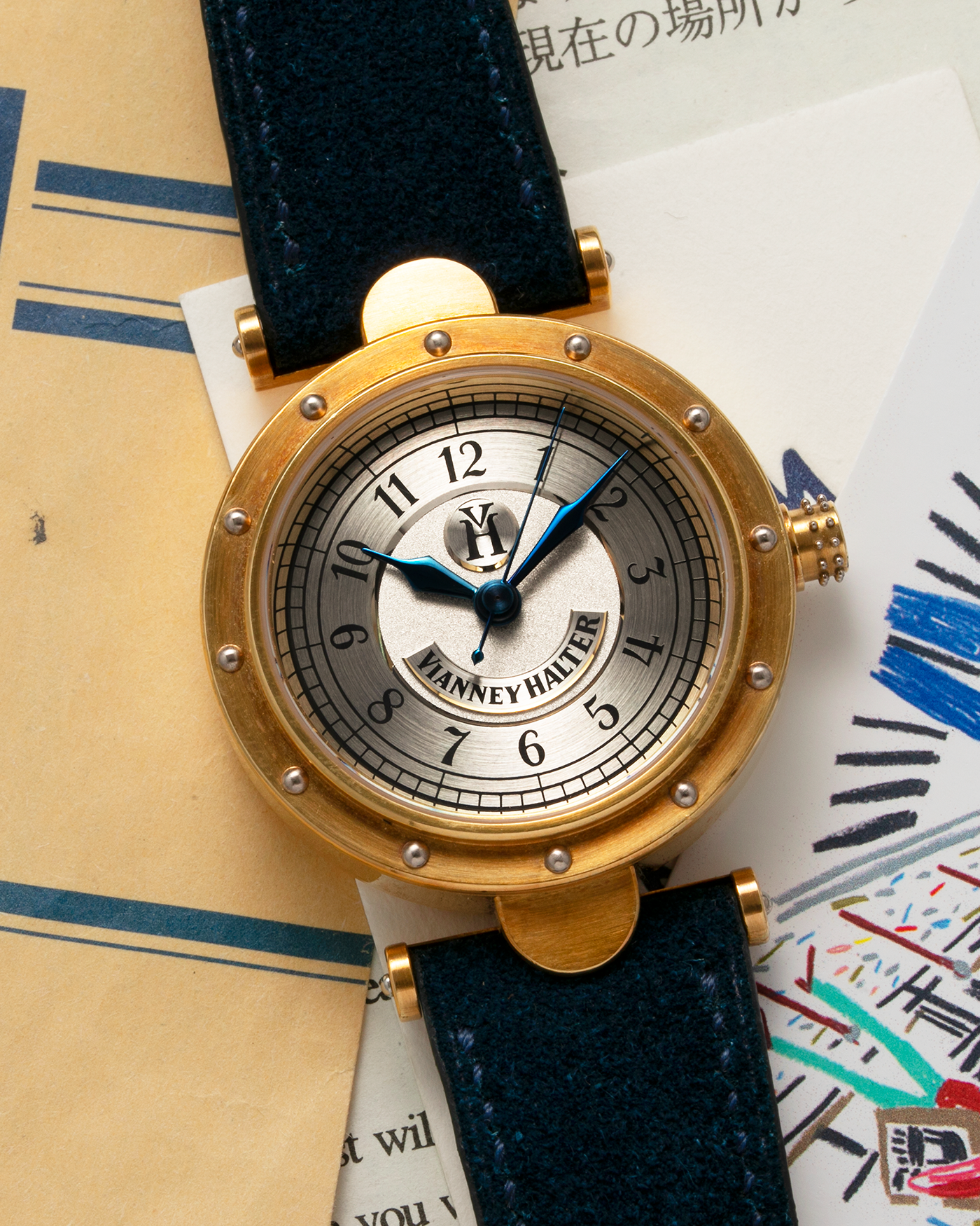 Brand: Vianney Halter Year: 2000’s Model: Classic Material: 18k Yellow Gold Movement: Modified Lemania 8810 with mystery motor Case Diameter: 36mm Bracelet/Strap: Blue Suede strap with Yellow Gold Tang Buckle