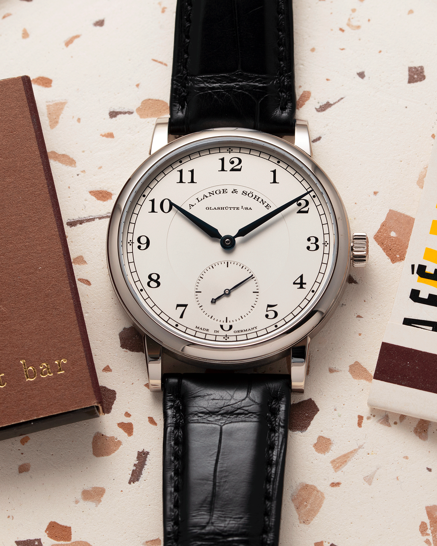 Brand: A. Lange & Sohne Year: 2010’s Model: 1815 Annual Calendar Ref Number: 235.026 Material: 18k White Gold Movement: Manual Winding In-House Cal. L051.1 Case Diameter: 38mm Bracelet/Strap: A. Lange & Sohne Black Alligator Strap with signed 18k White Gold Tang Buckle